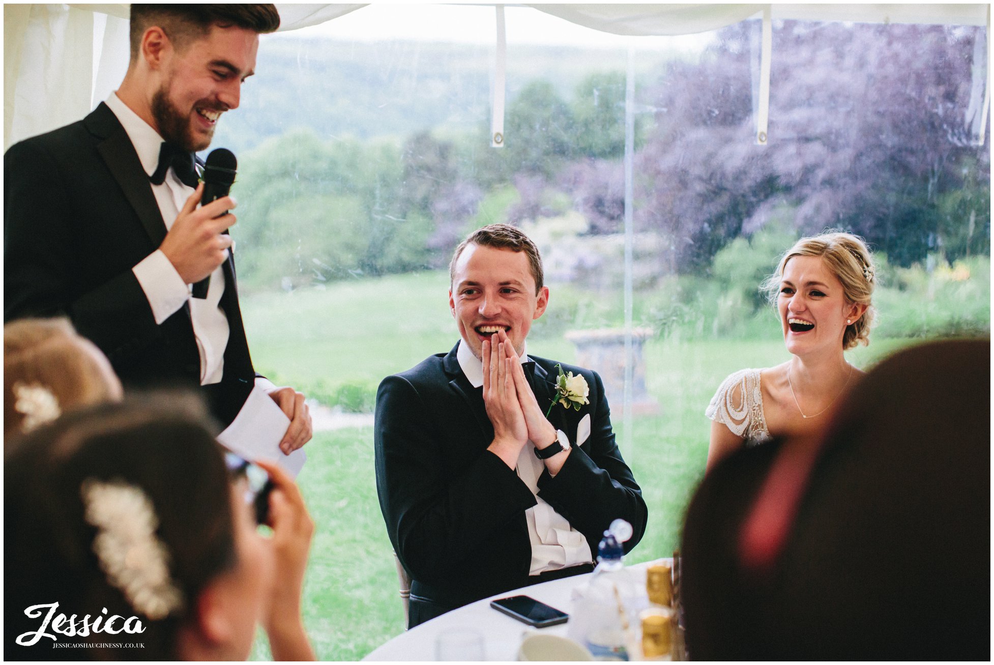 groom looks shocked during the best man's speech