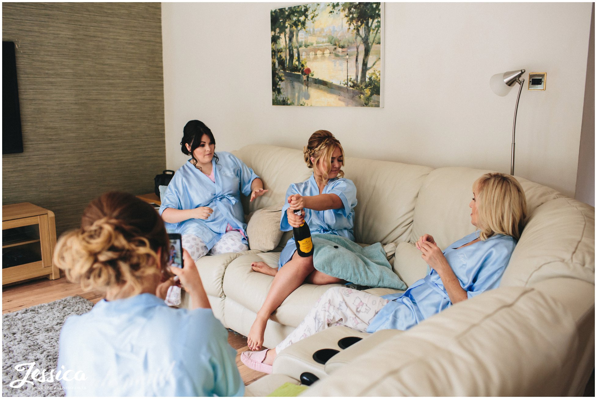 bridemaids open champagne on the morning of the wedding