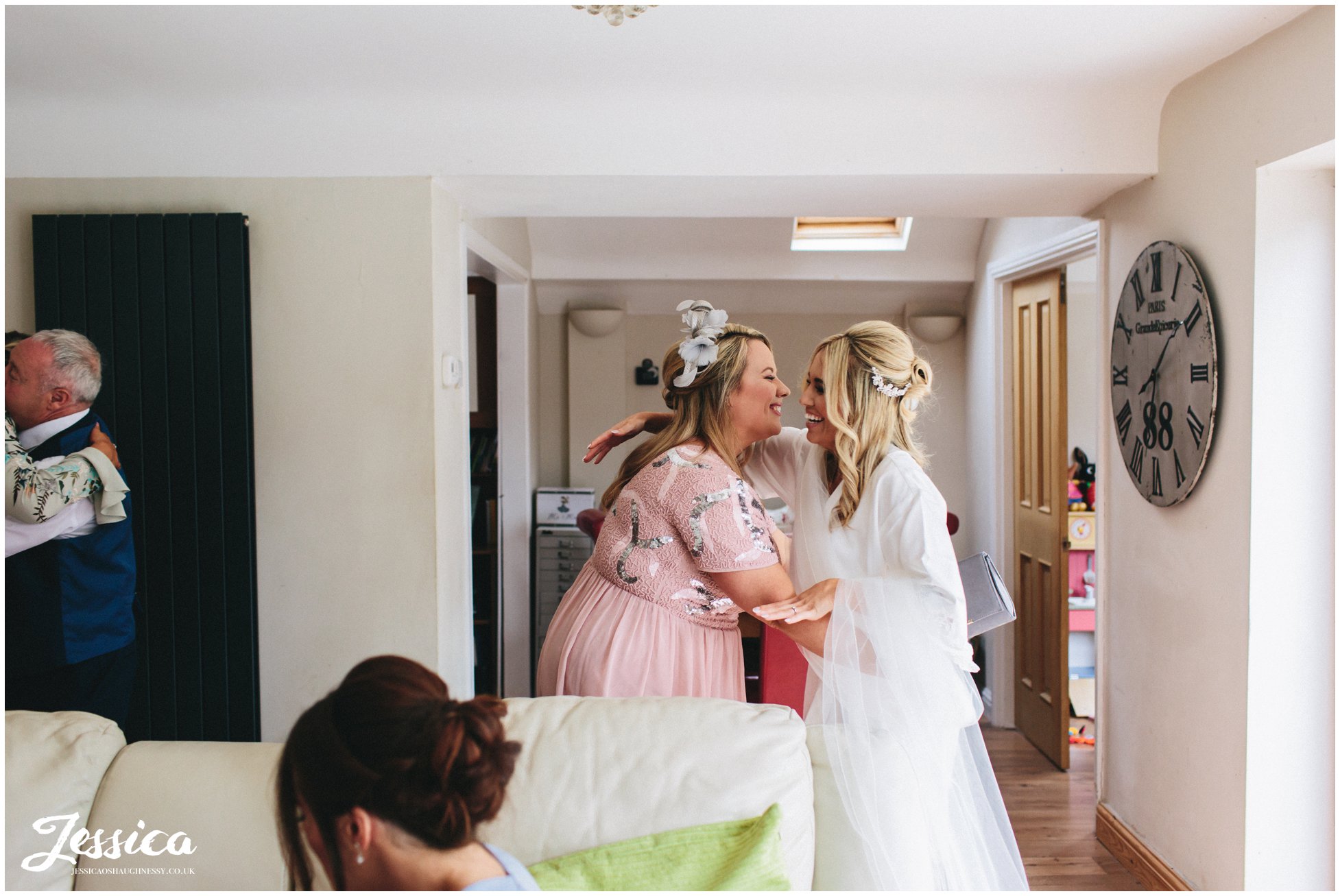 friend hugs bride on the morning of her wedding on the wirral