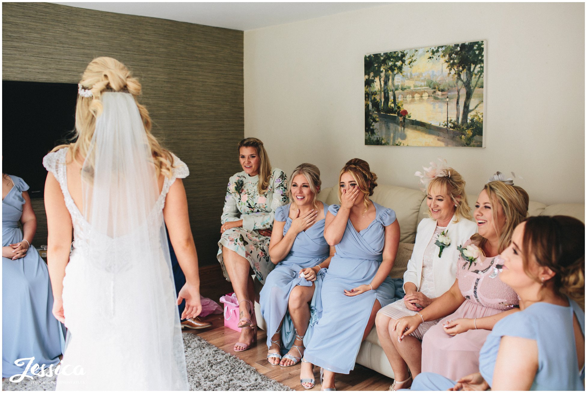 bridesmaids gasp at bride in her wedding dress