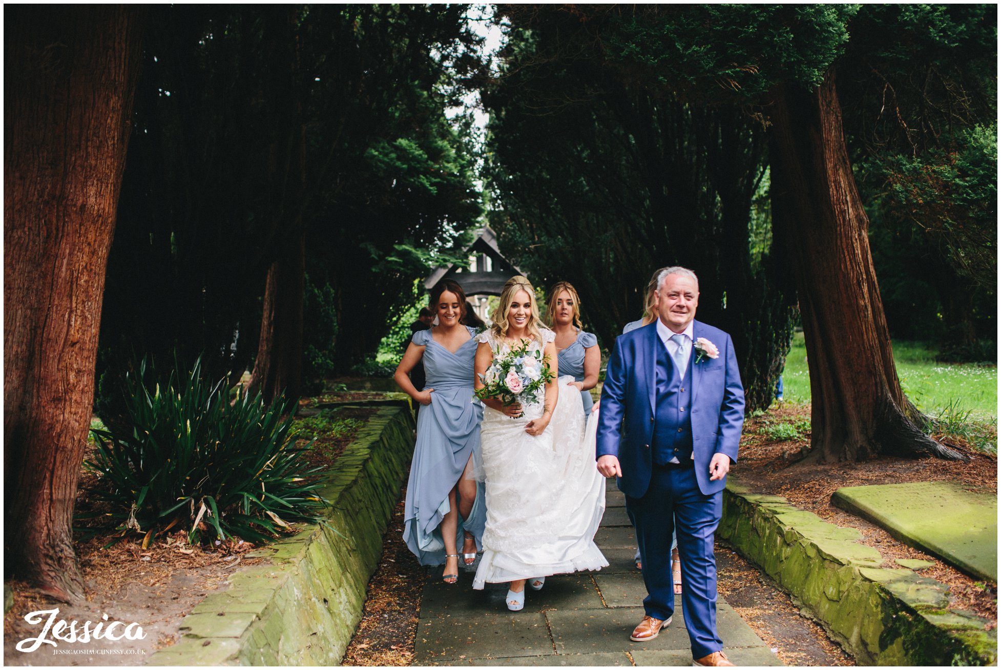 bride and bridesmaids walk down church path - wirral wedding