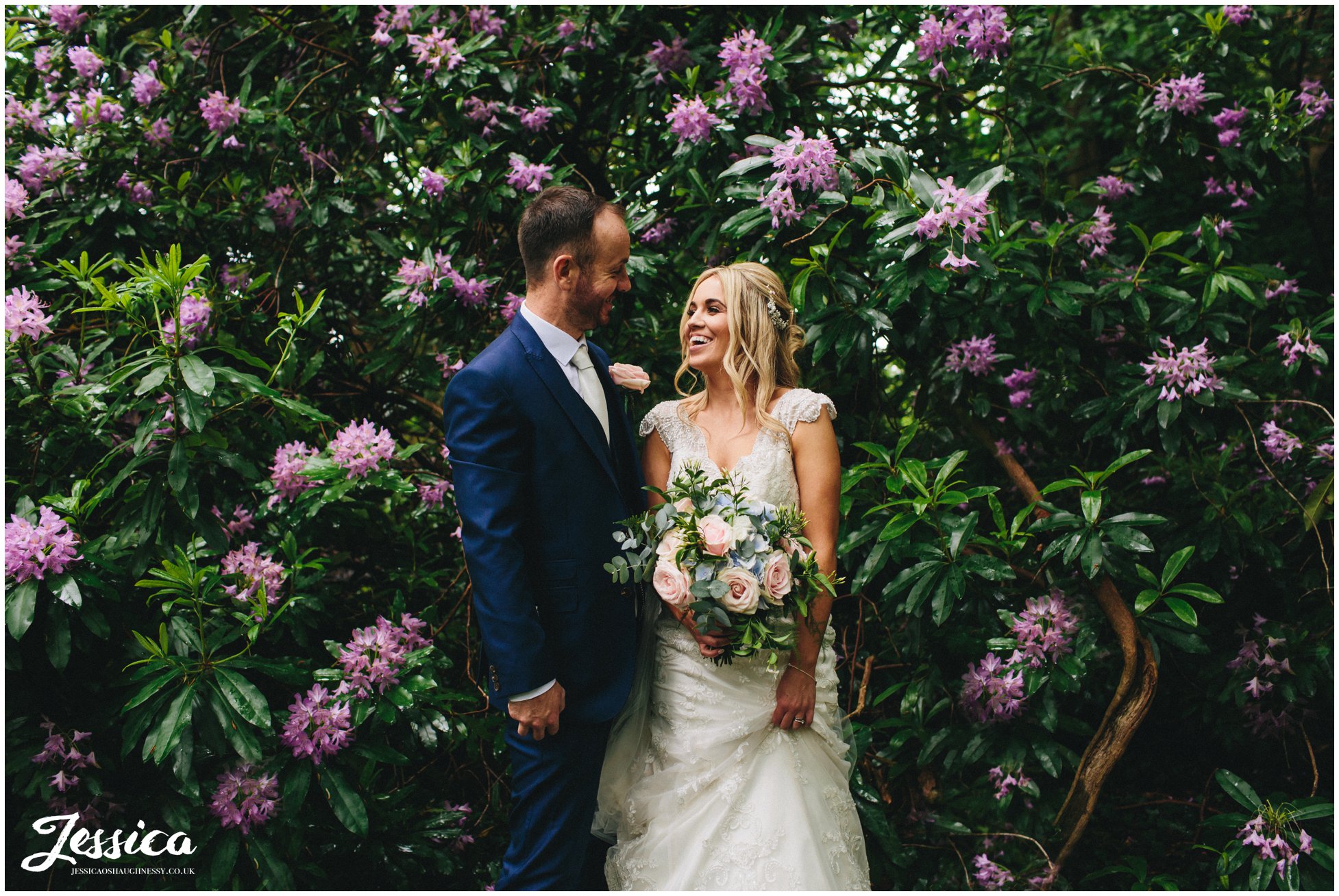 bride & groom surrounded by purple flowers on their wedding day at thornton manor