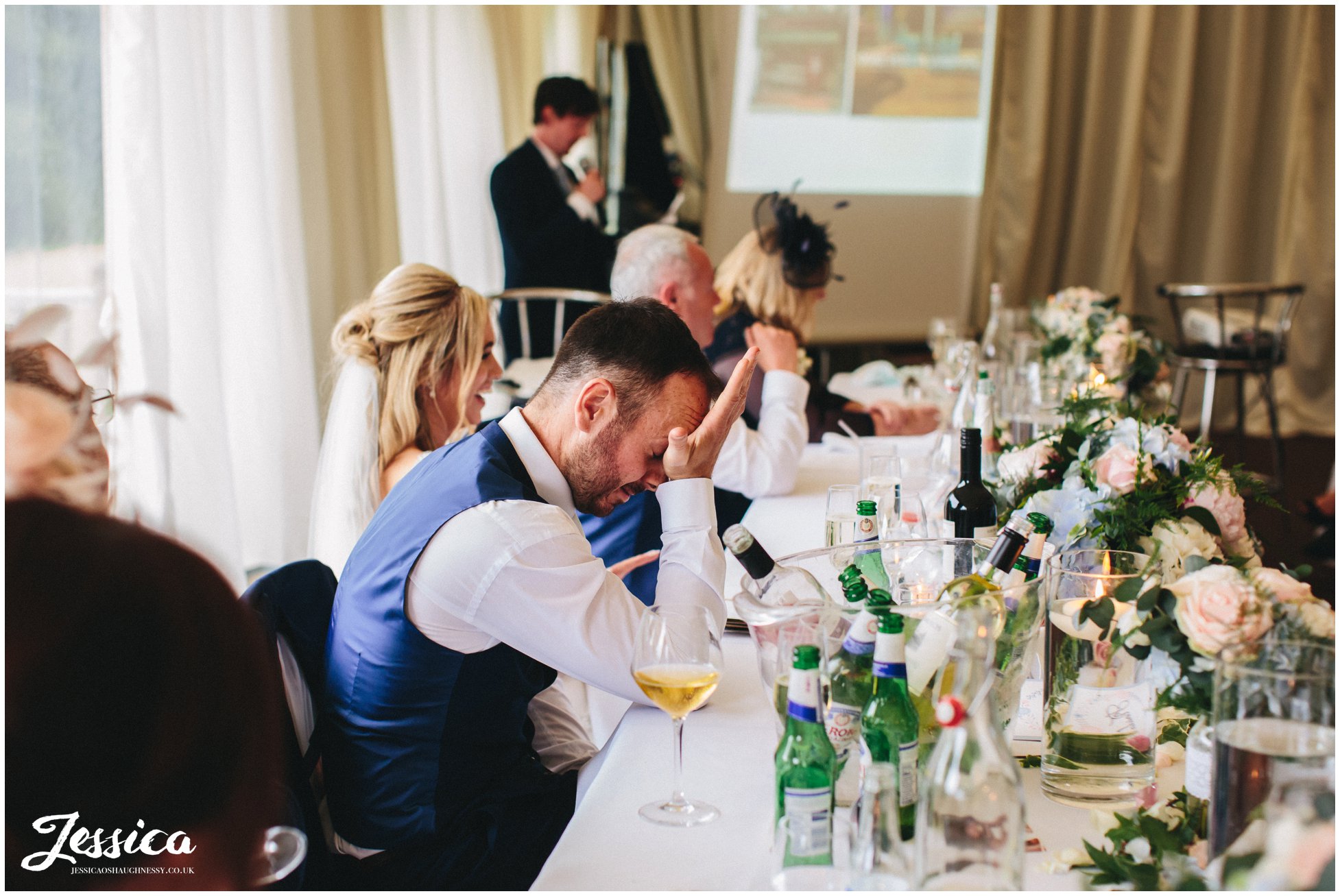 groom looking embarrassed during best man's speech
