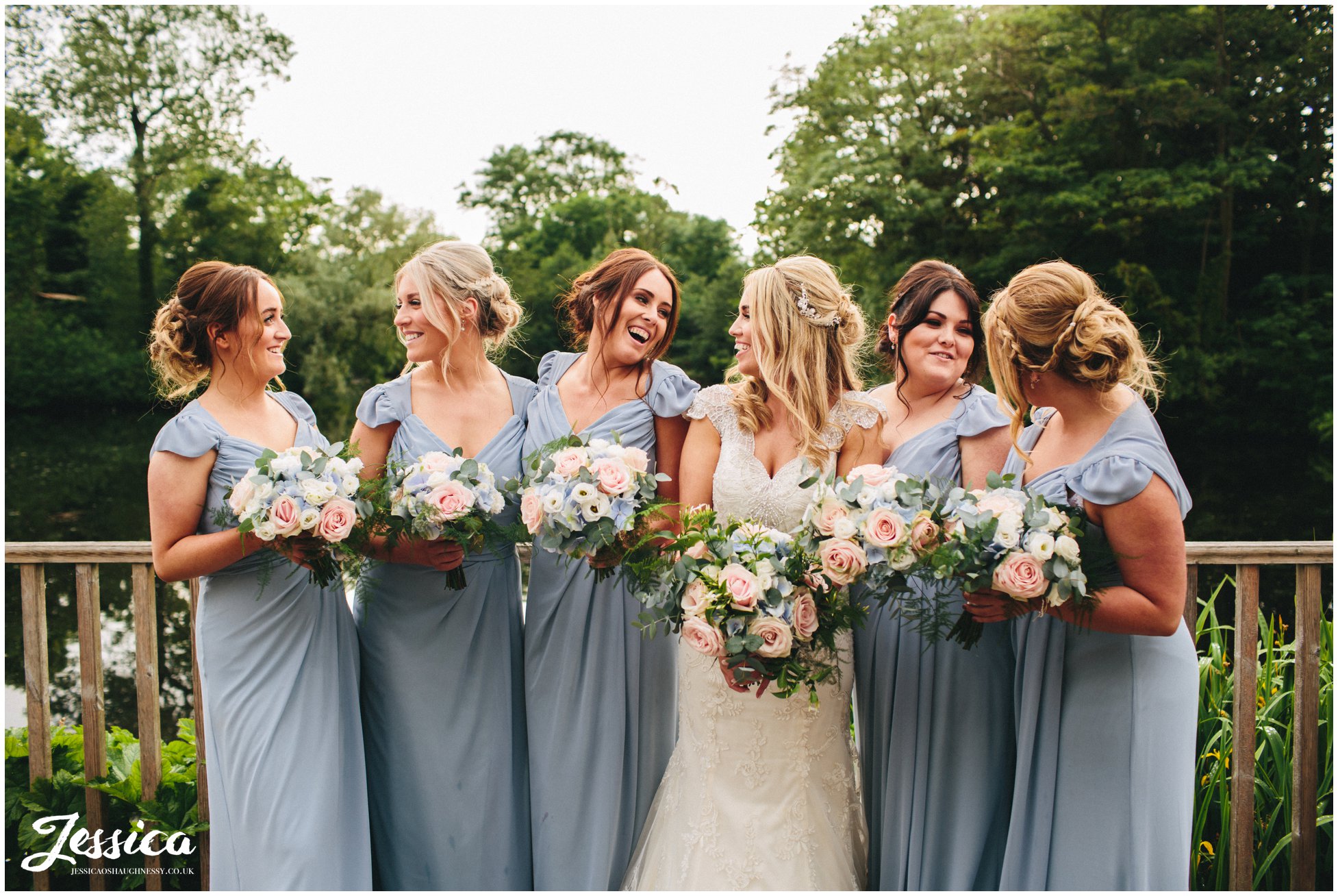 bridesmaids pose in front of lake at thornton manor, on the wirral