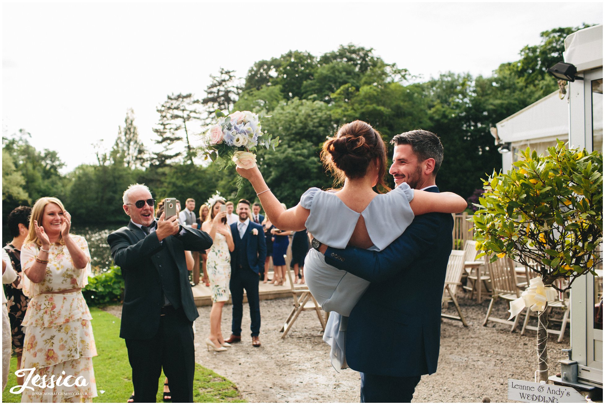 bridesmaid catches bouquet and is lifted up by her partner