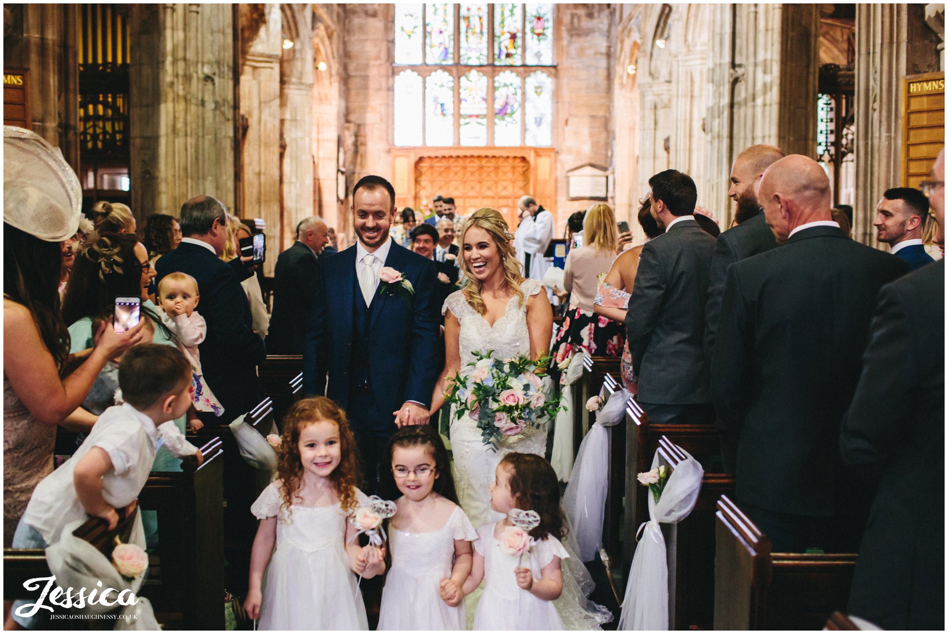 bride, groom & flower girls exit church after their ceremony