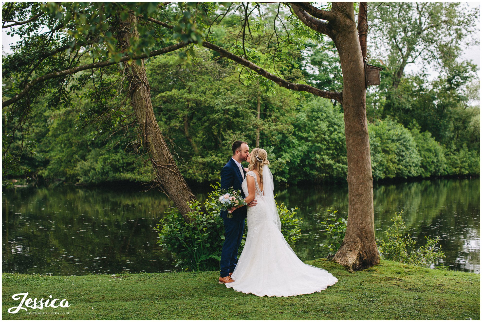 newly wed's kissing by the lake at thornton manor