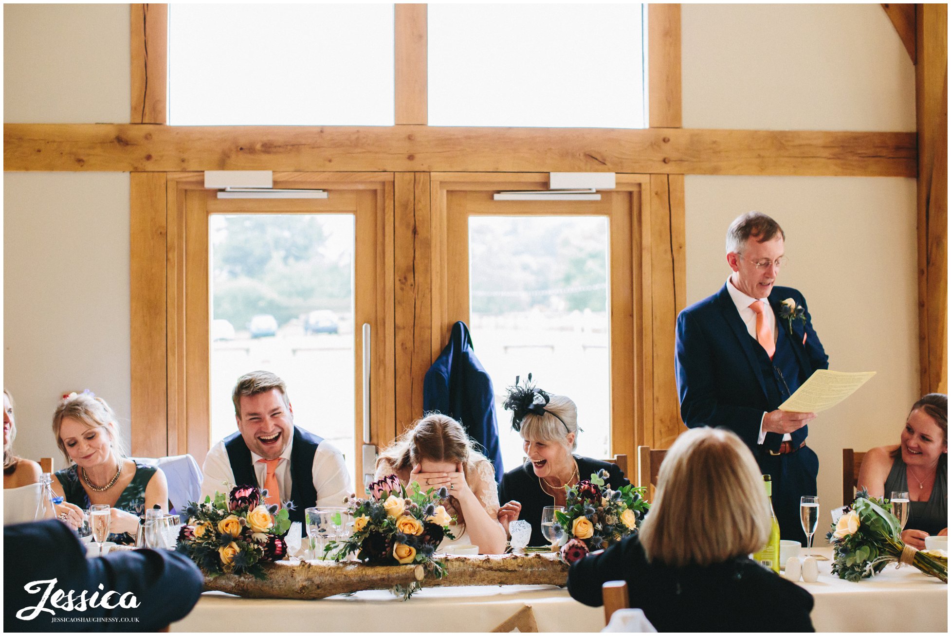 father of the bride giving his speech as daughter looks embarrased