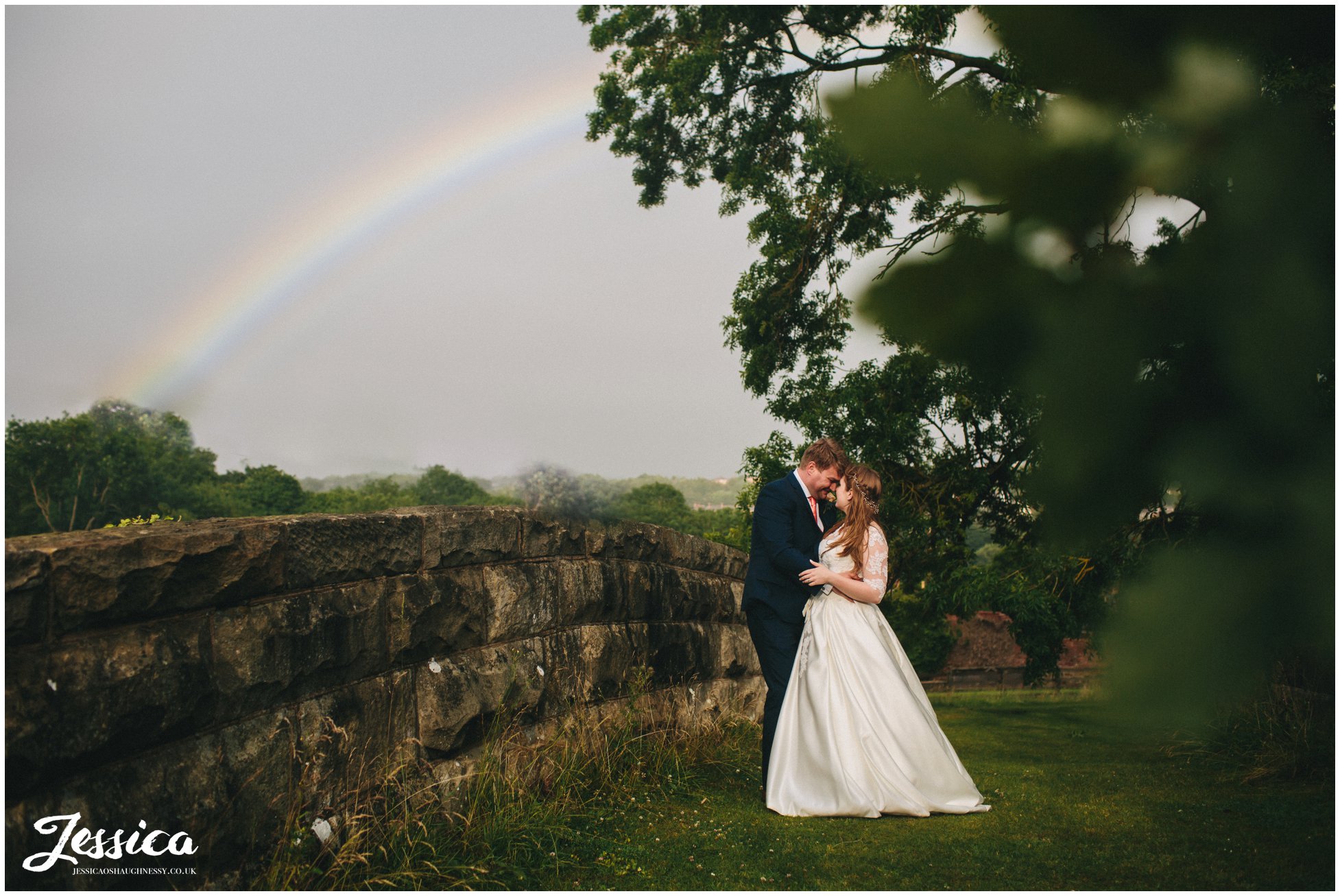 bride & groom stand under a rainbow that appeared over tower hill barns