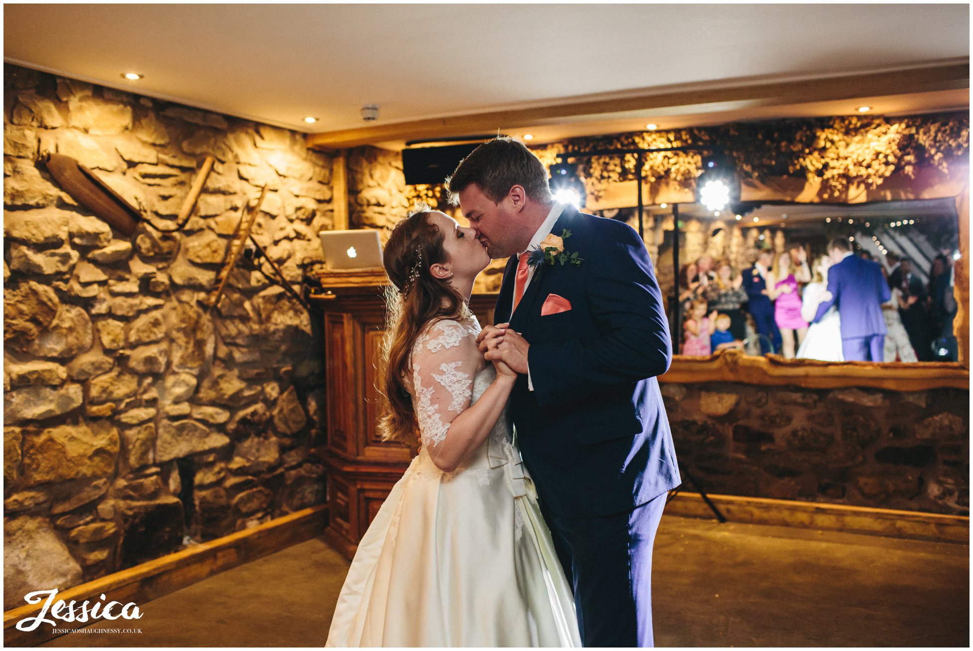 bride & groom kiss during their first dance in the old barn