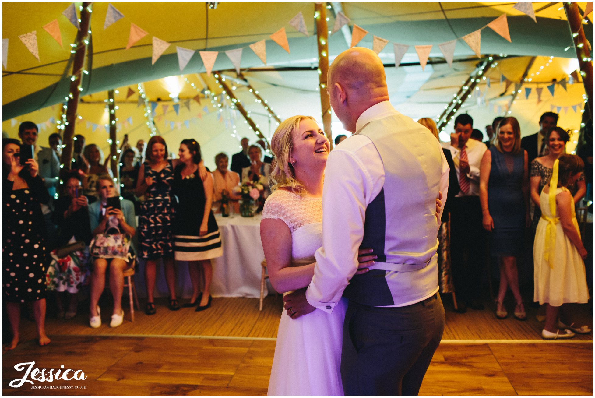 bride and groom share their first dance in the tipi