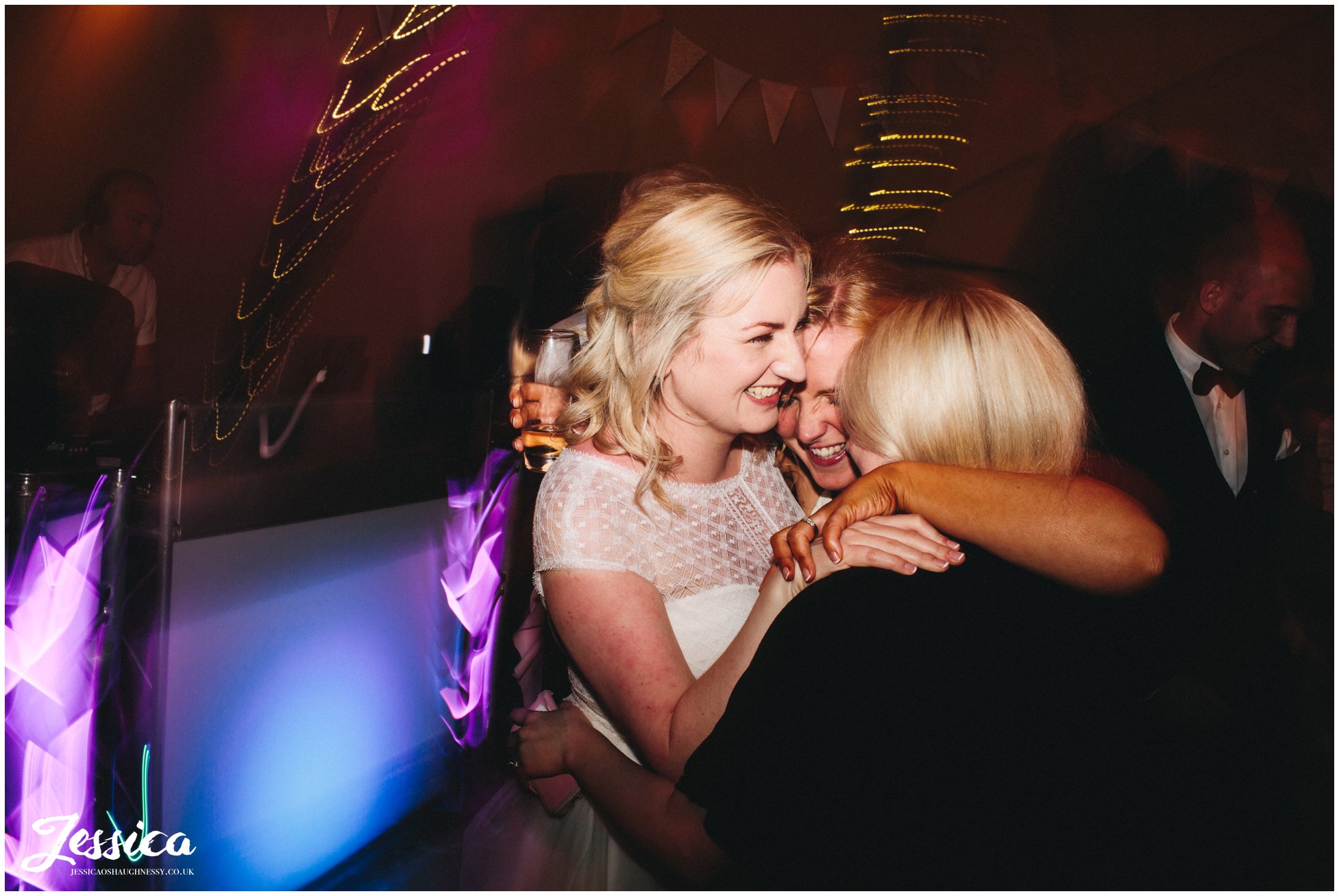 bride and friends hugging on the dancefloor - tipi wedding