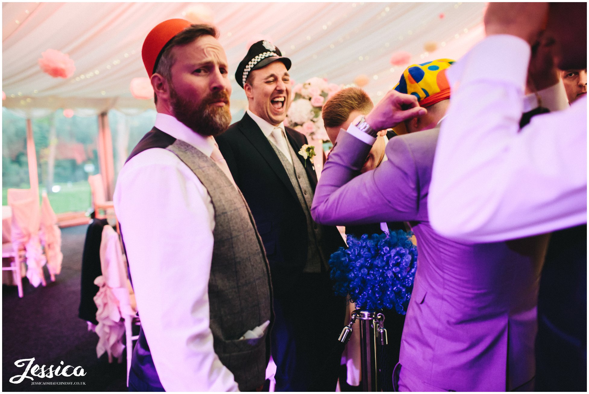 groom trying on props for the wedding photo booth