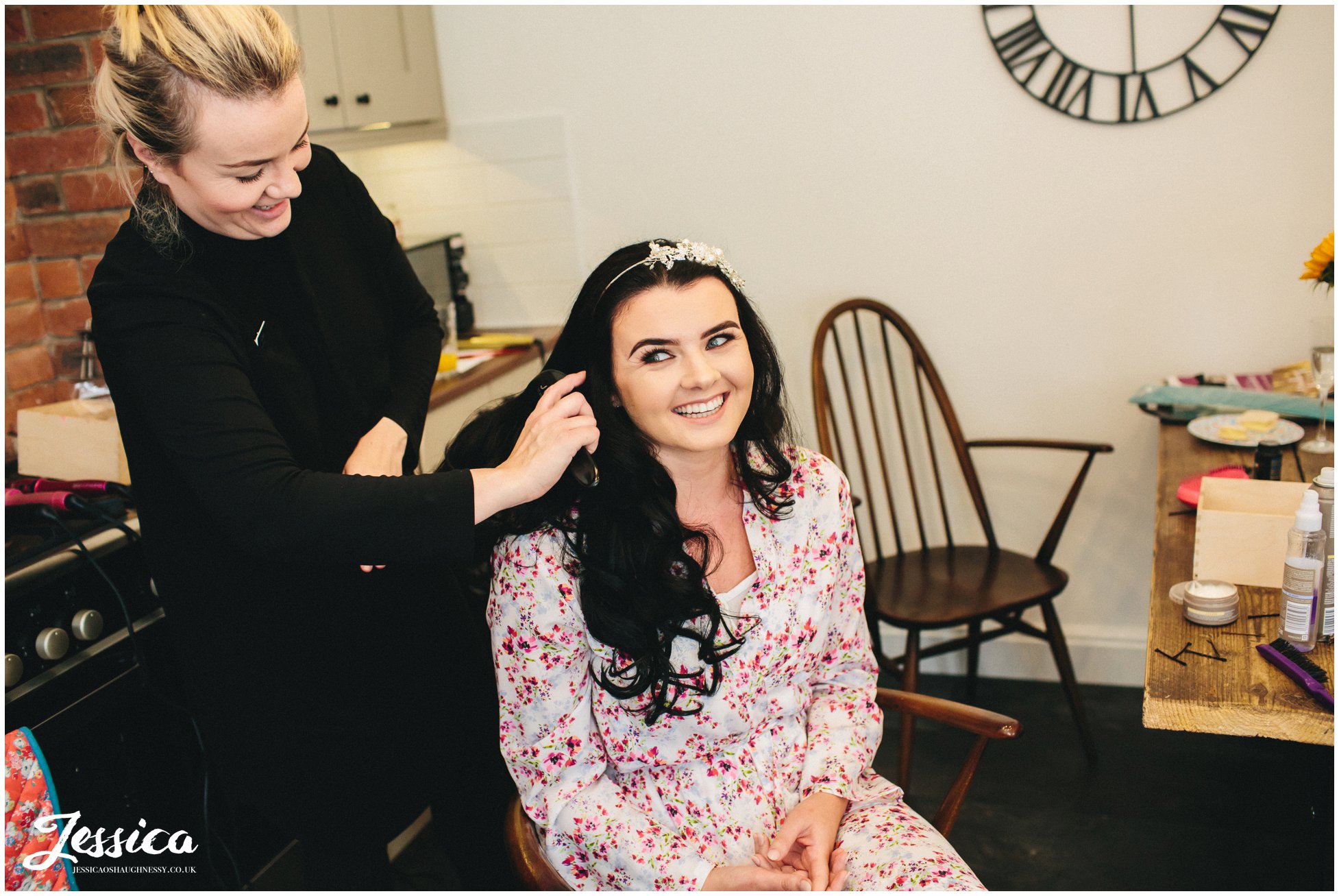 bride gets makeup done on her wedding morning