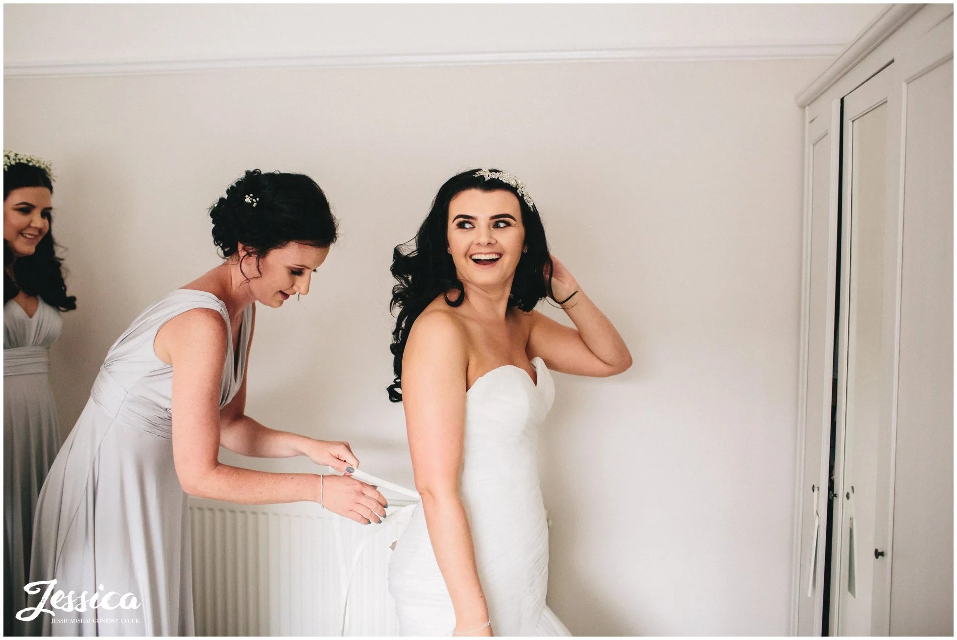 bride gets into her wedding dress with help from bridesmaids
