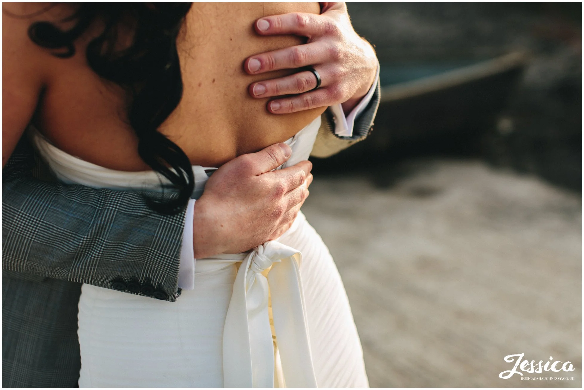 close up of grooms hands on brides back