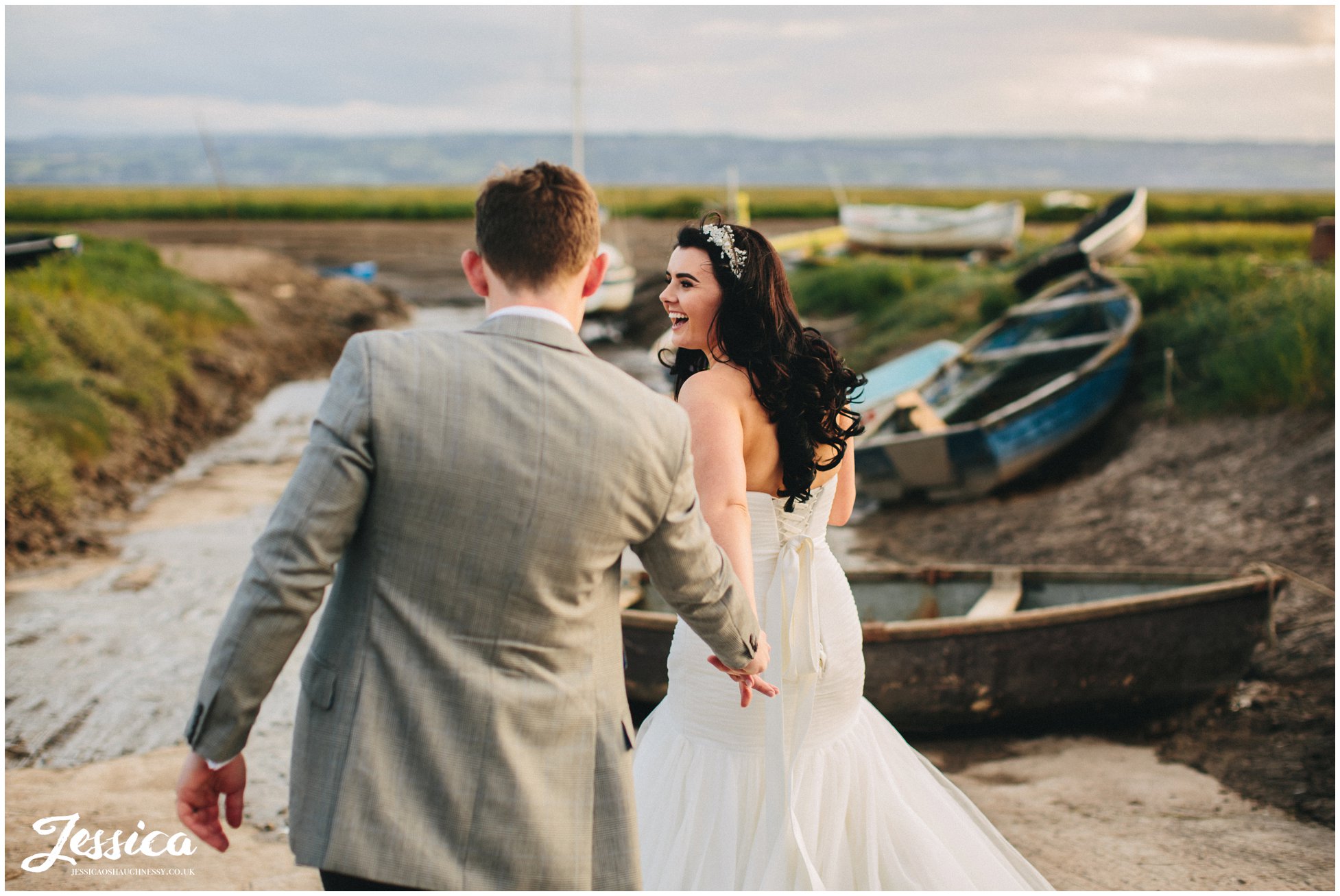 bride drags groom towards the water, wirral wedding photographer