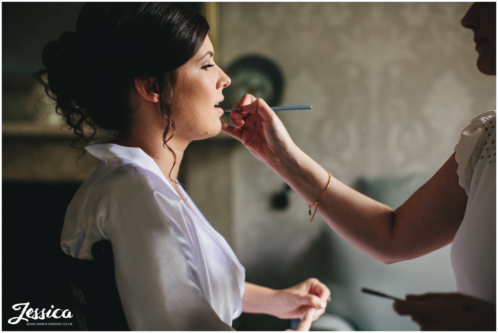 bride gets lipstick applied by make up artist