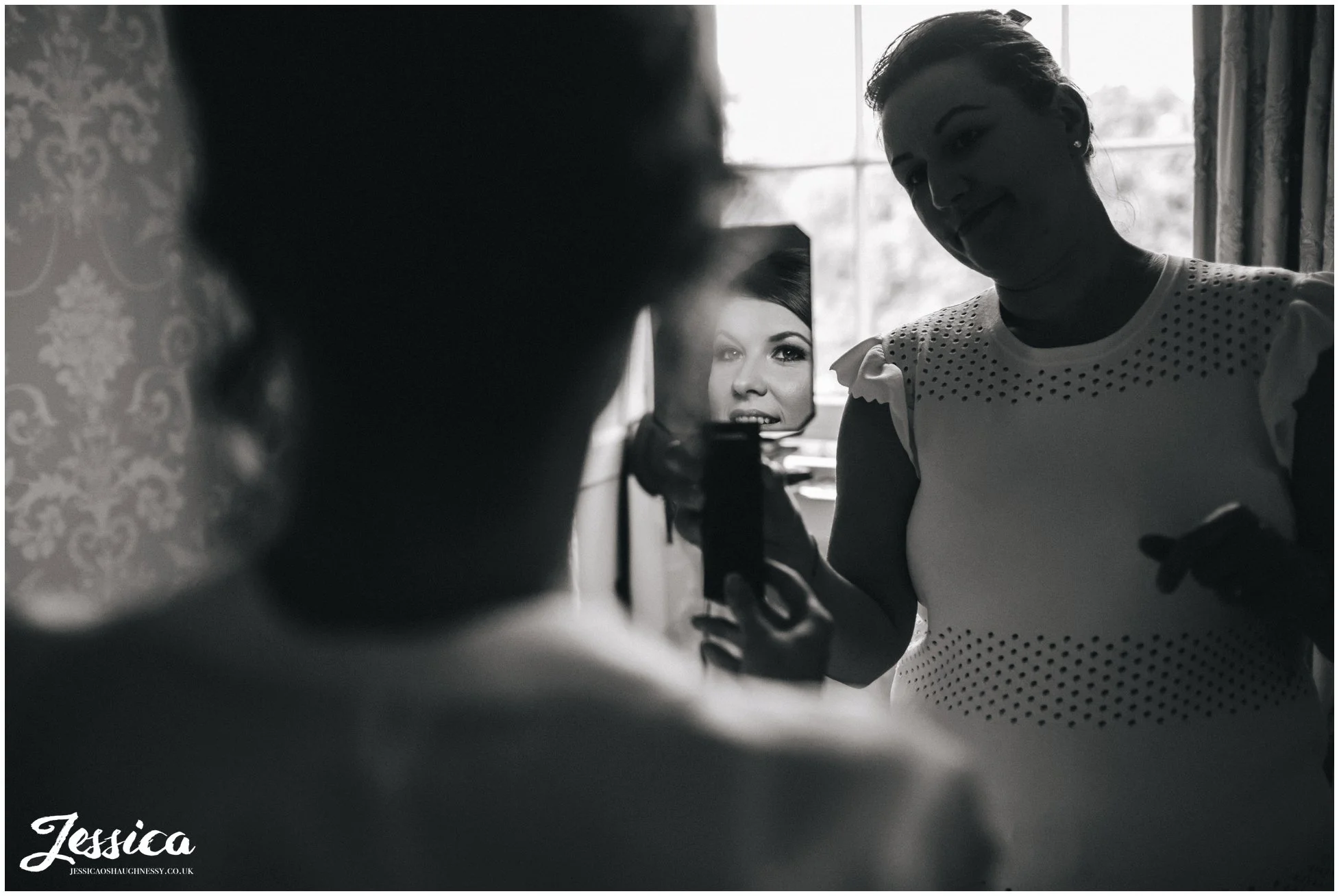bride looking at her makeup in the mirror at prestwold hall