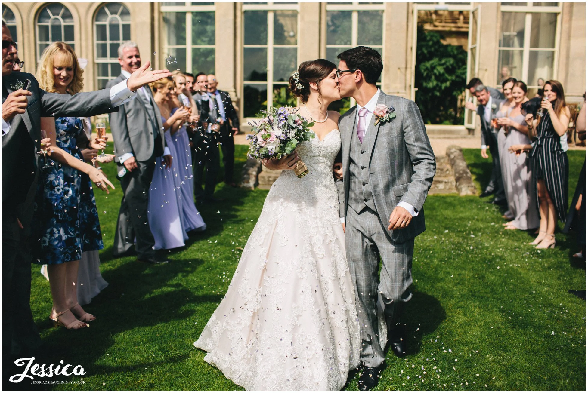 bride & groom kiss during confetti line