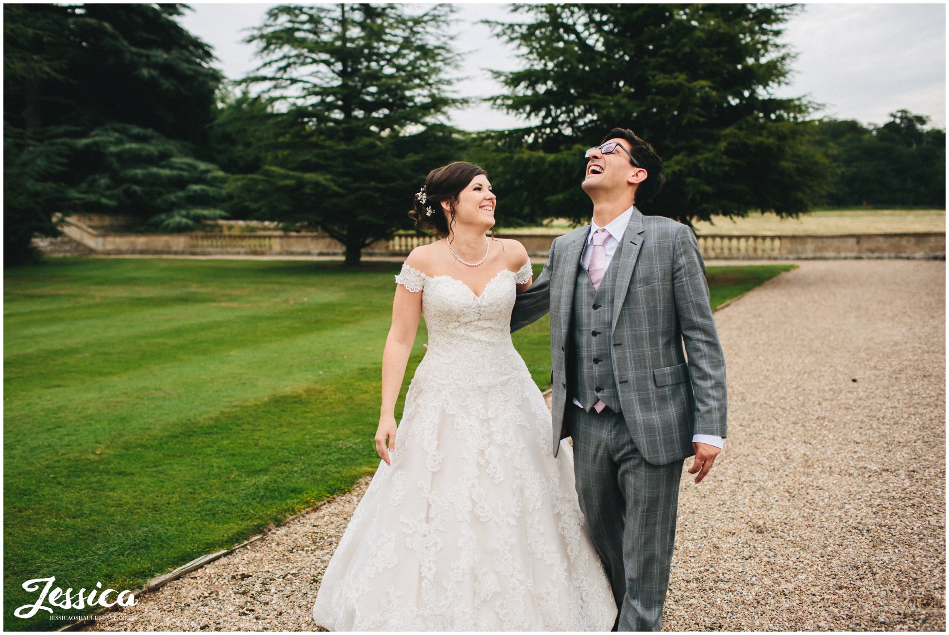 bride and groom walk through prestwold hall laughing