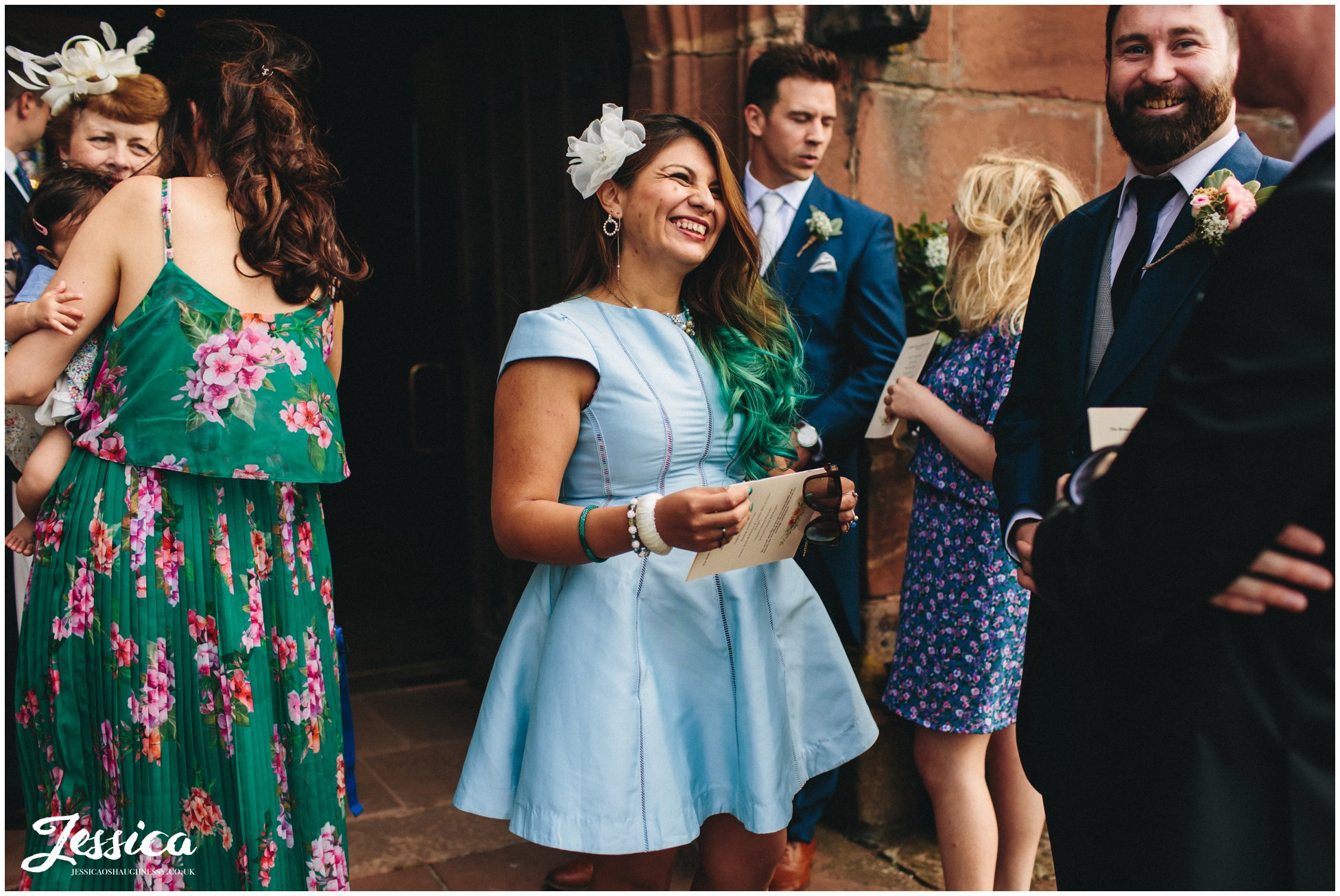 wedding guests laughing outside church