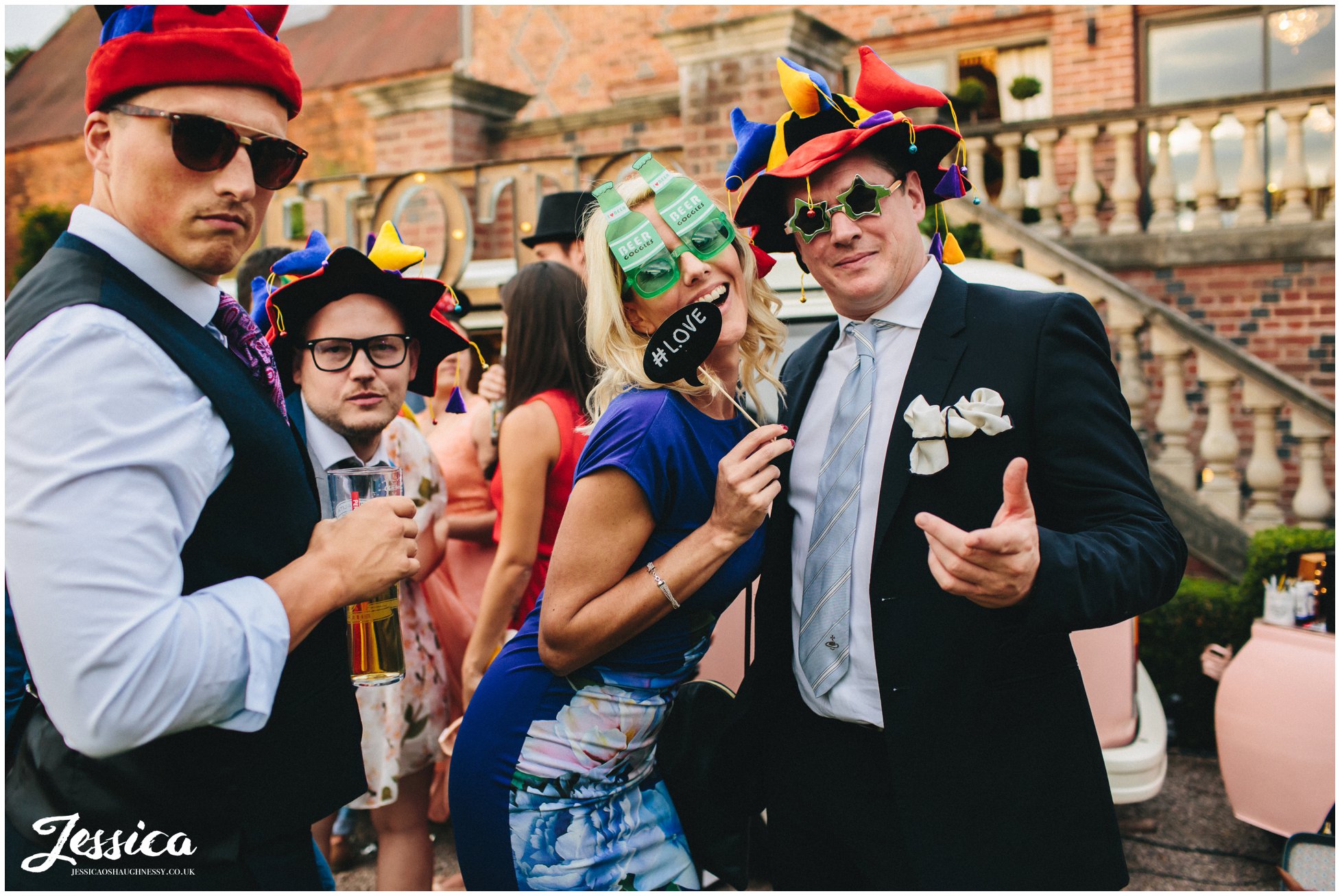 wedding guests pose with props at a wedding in cheshire