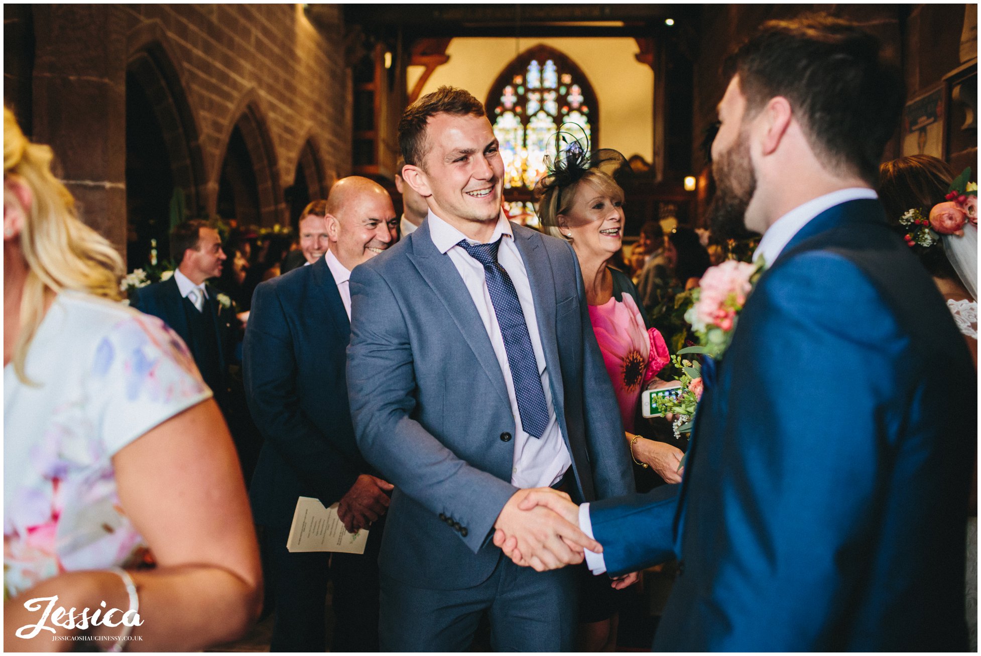 guest shakes grooms hands after wedding ceremony