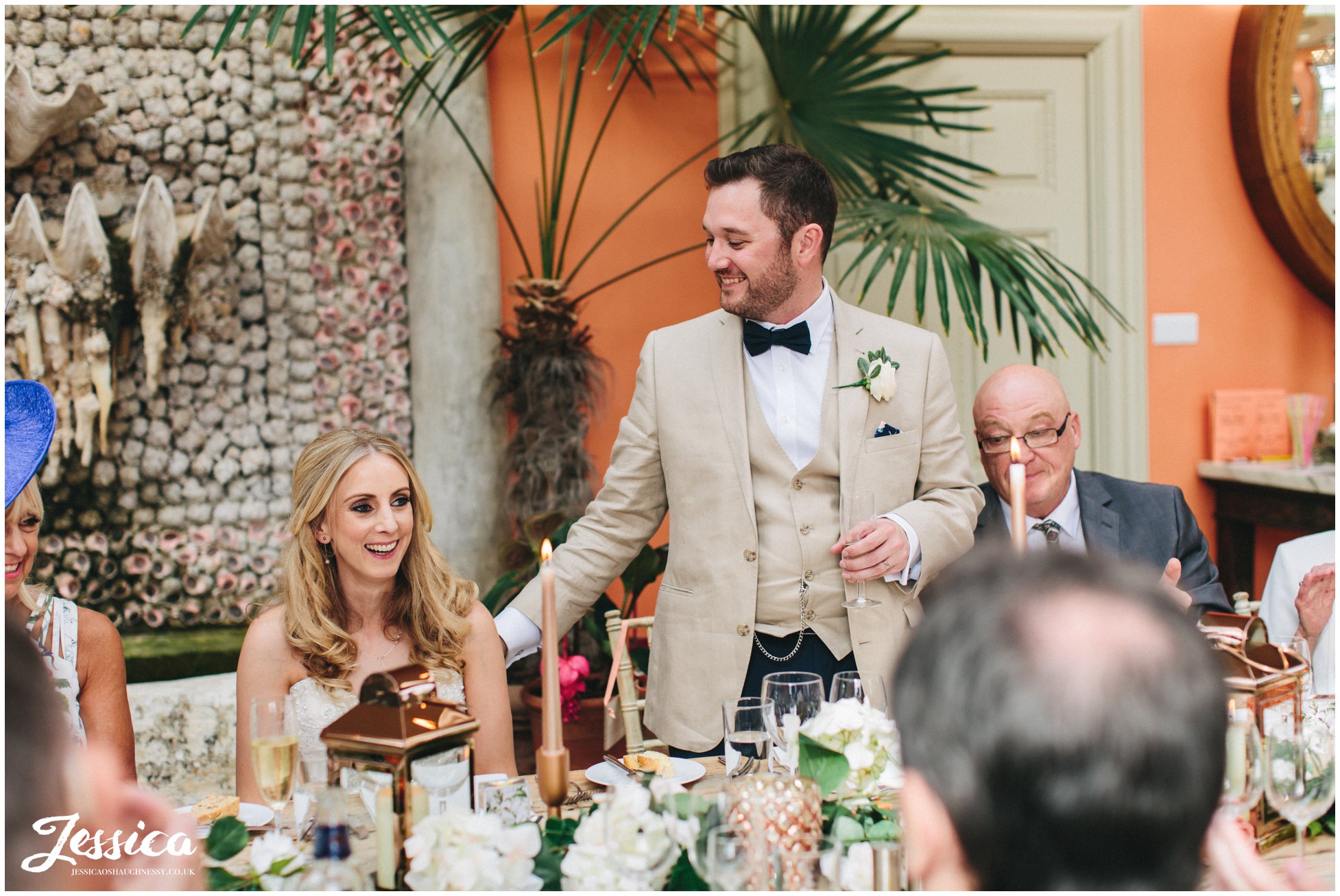 groom stands to give speech on his wedding day at the lost orangery