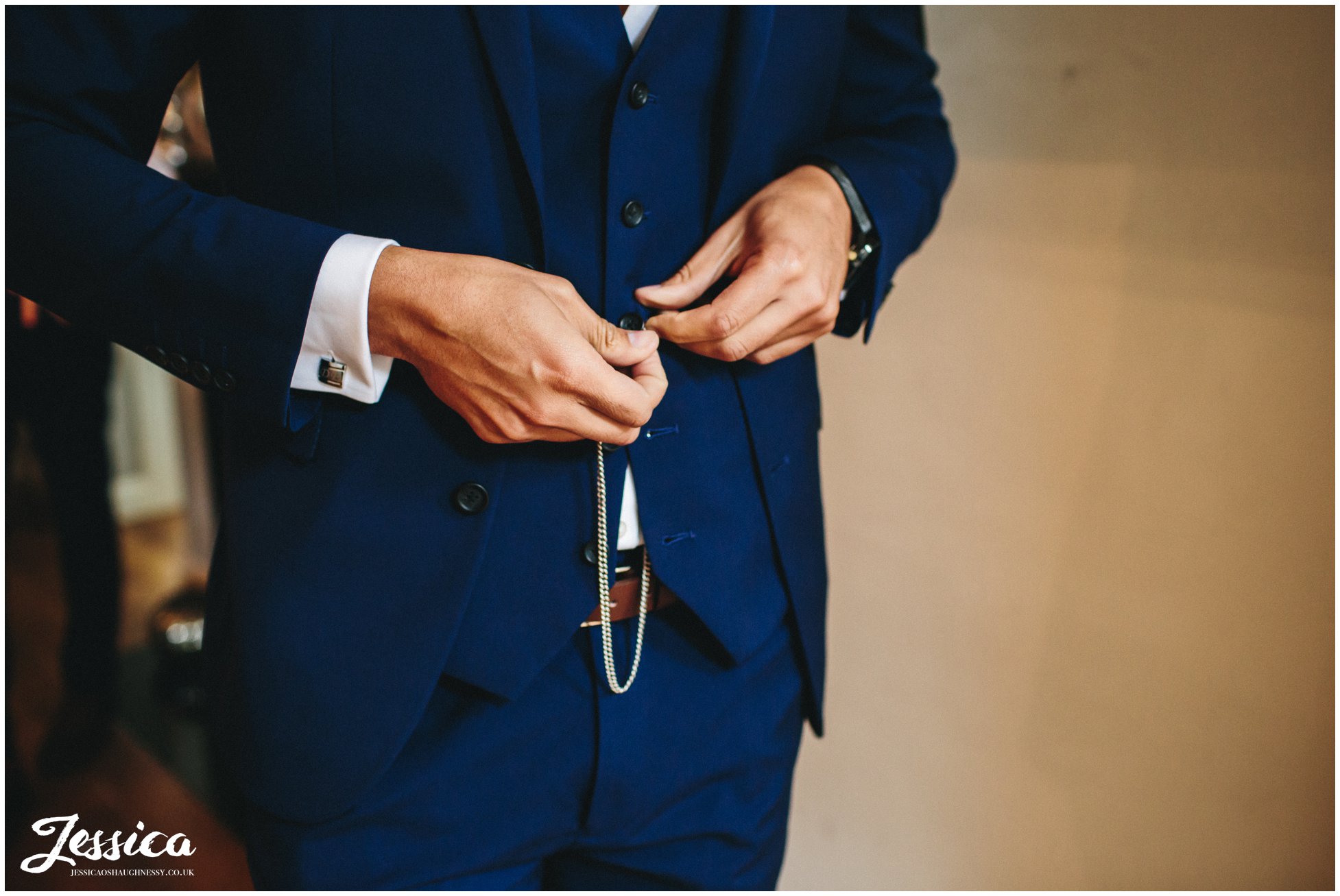 groom attaches his pocket watch to his waistcoat - cheshire wedding photography