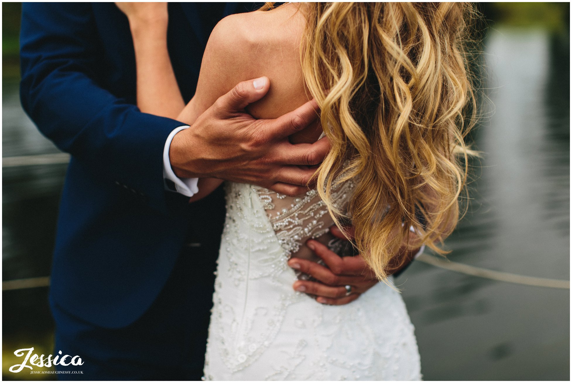 couple embrace at the lakeside in merrydale manor in cheshire