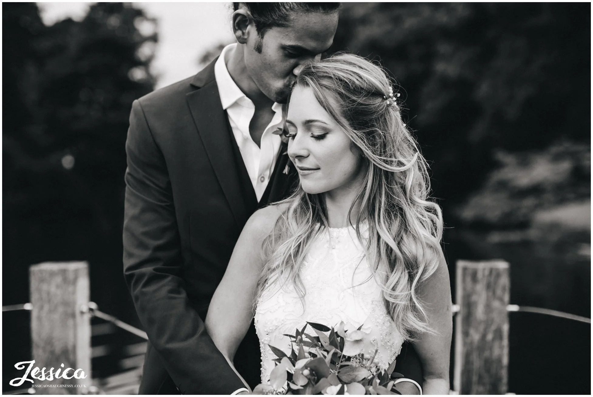 black and white romantic shot of the couple by the lake
