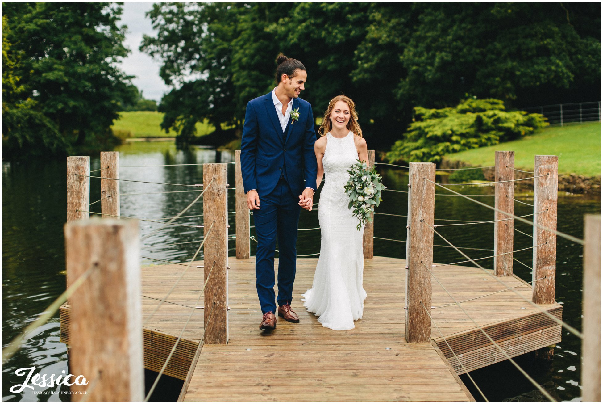 couple walk hand in hand down merrydale manor's jetty