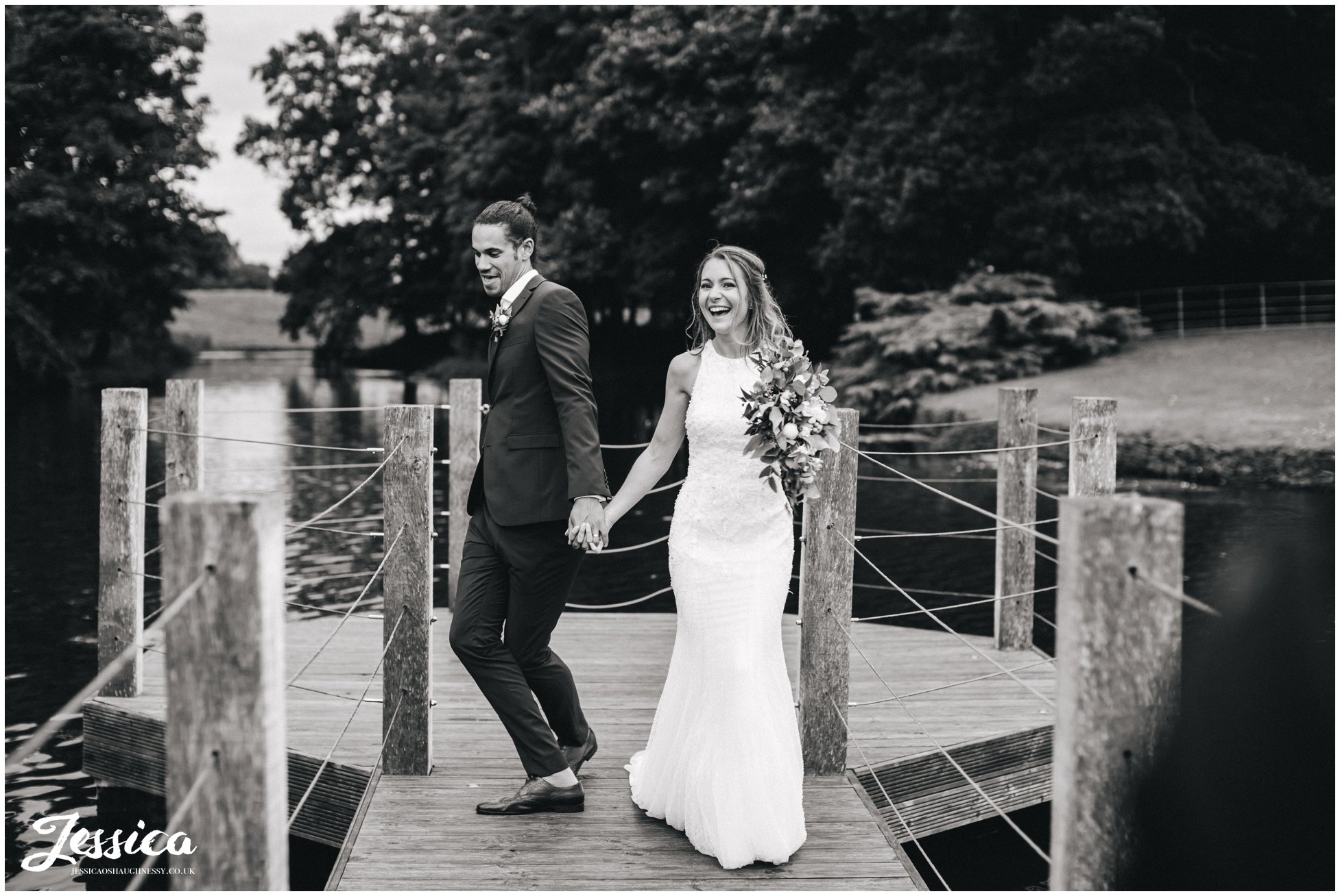 couple joking around walking down the jetty at merrydale manor in cheshire