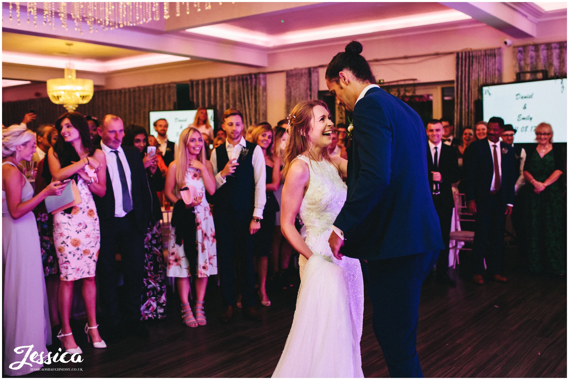 bride giggles during their first dance as husband and wife