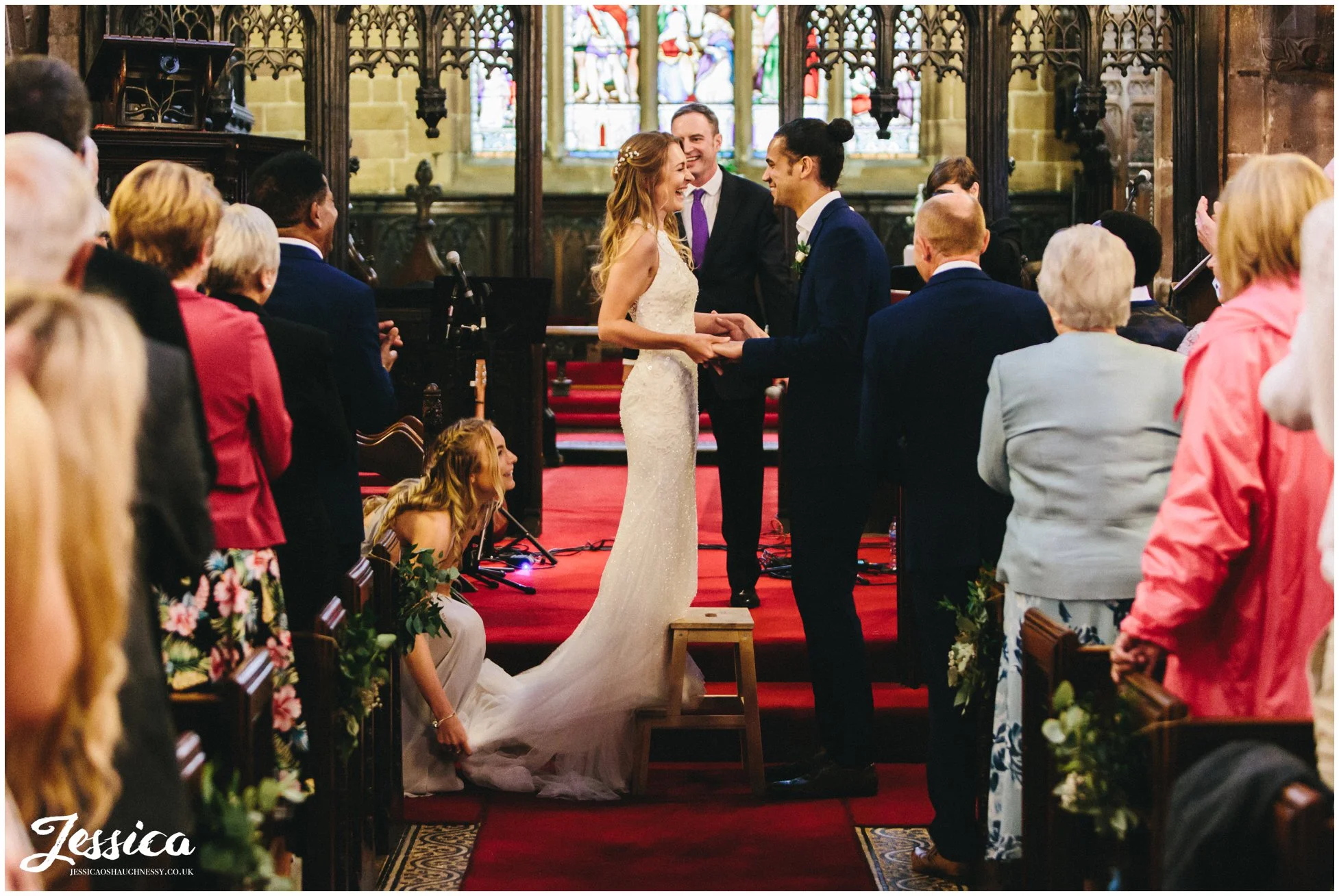 bride stands on stool to kiss her tall husband