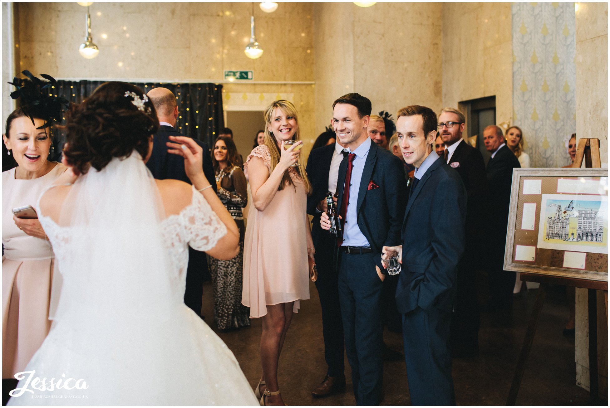 guests smile as newly wed's return to their wedding reception