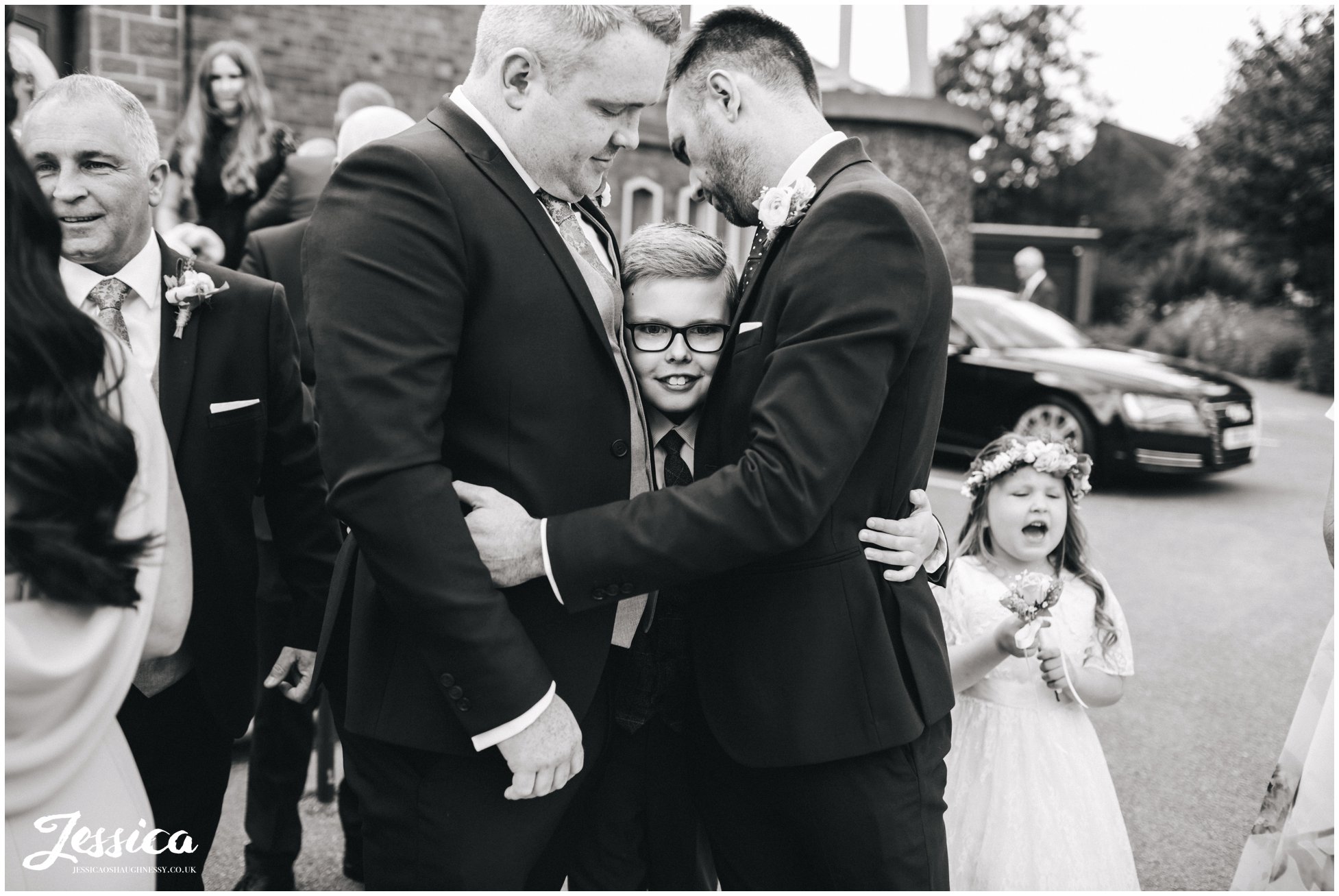 guests hug page boy after the wedding ceremony at Holy rosary church