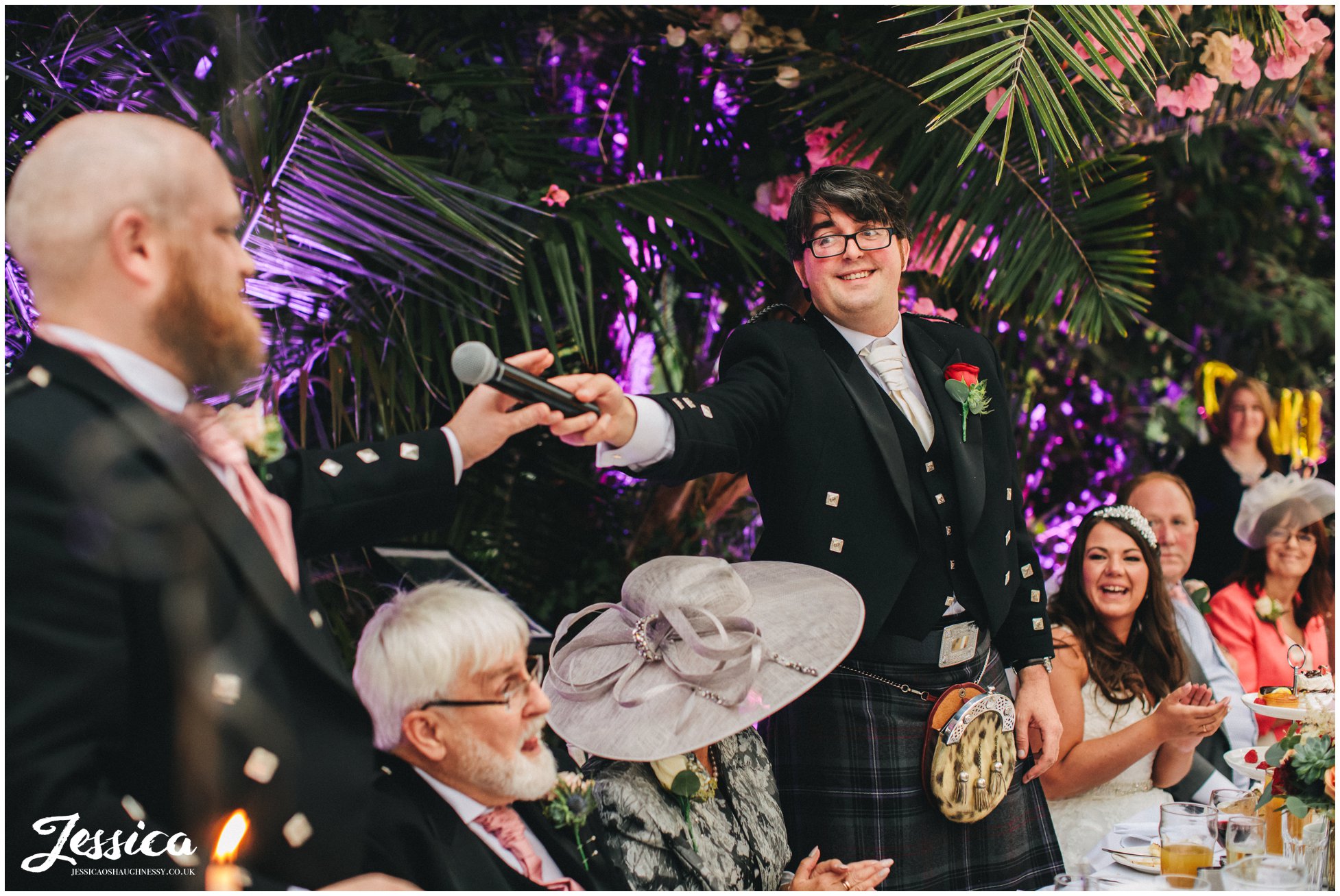 groom hands microphone to the best man