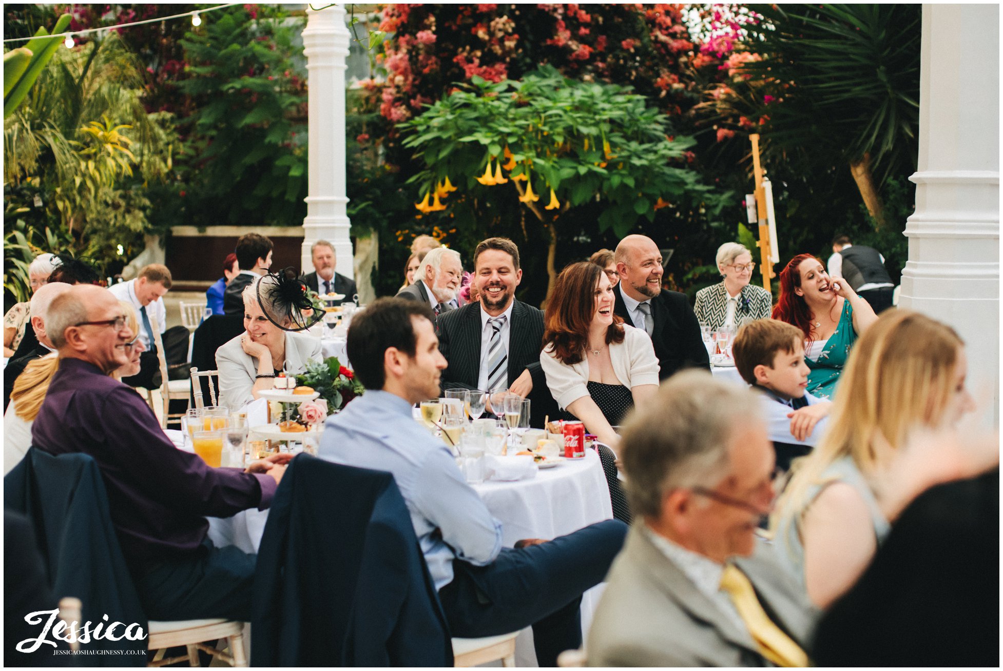 wedding guests laughing round decorating tables