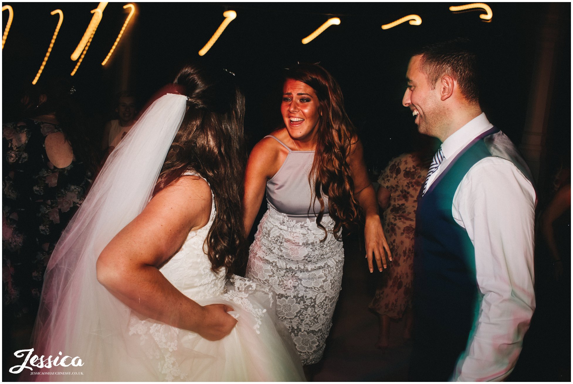 guests laugh with the bride on the dancefloor