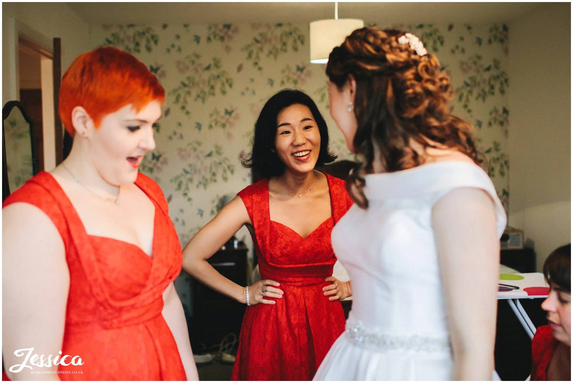 bridesmaid admires the bride in her wedding dress