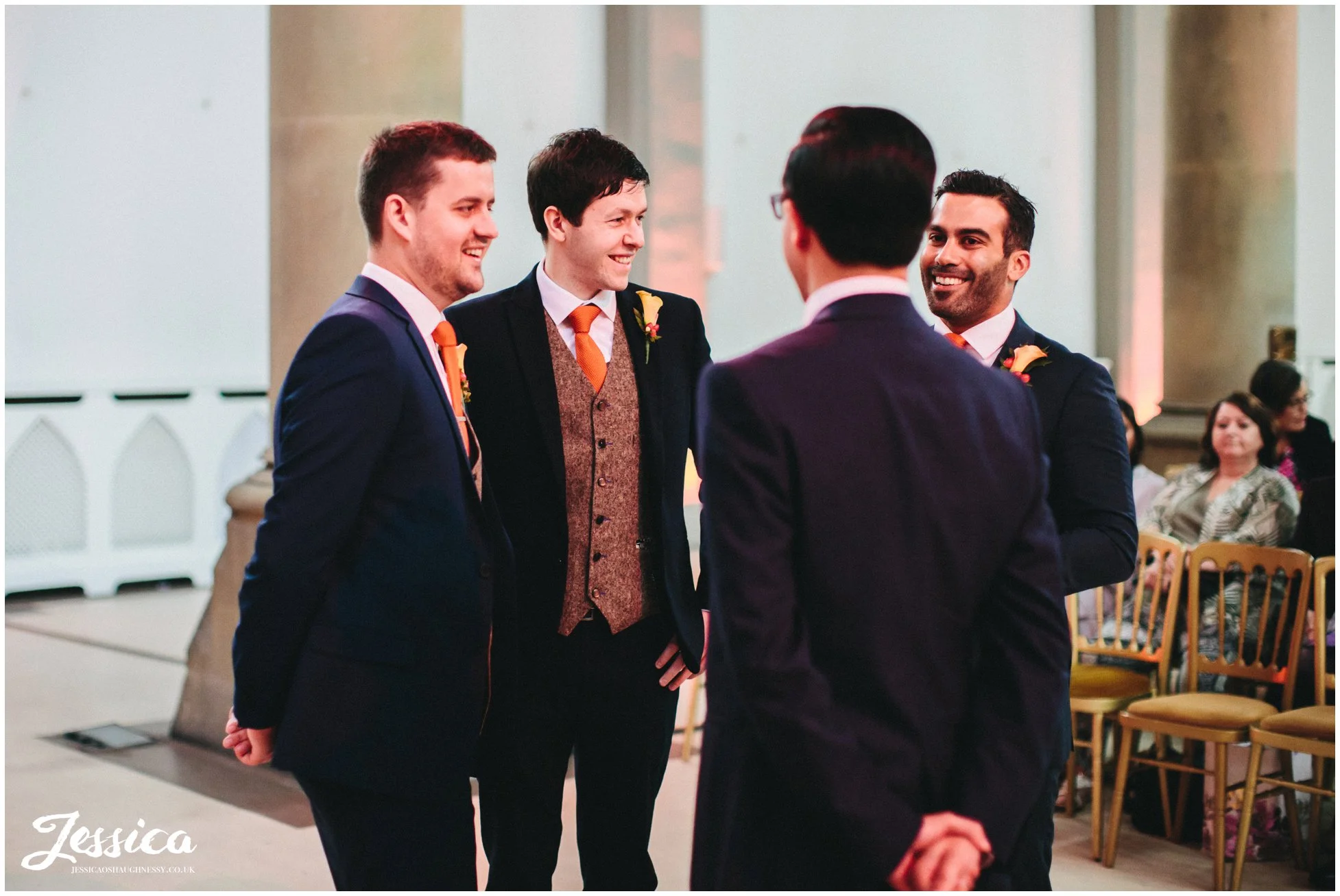 groom stands with groomsmen at the alter awaiting the bride