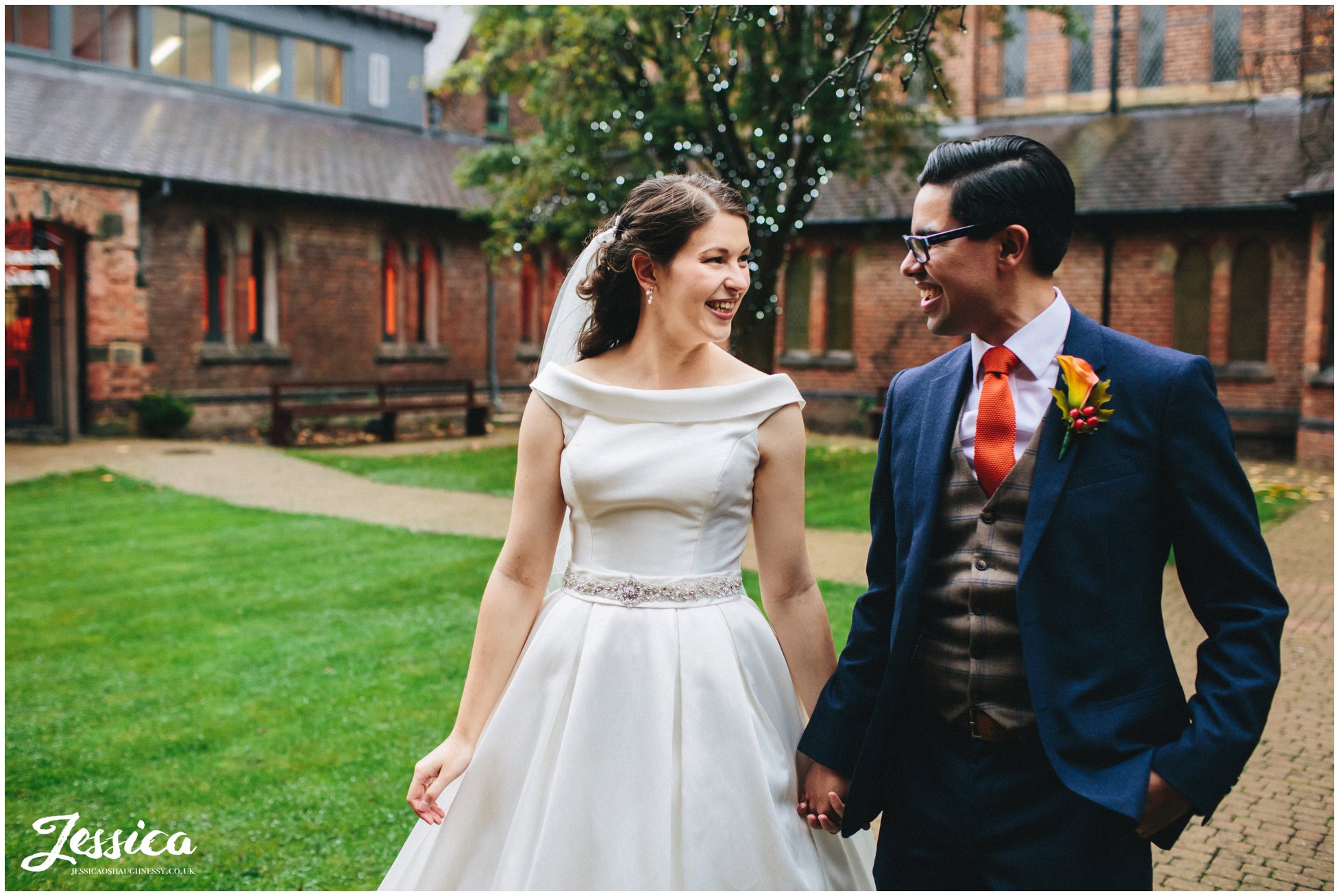 newly wed's walk hand in hand through gorton monastery's courtyard