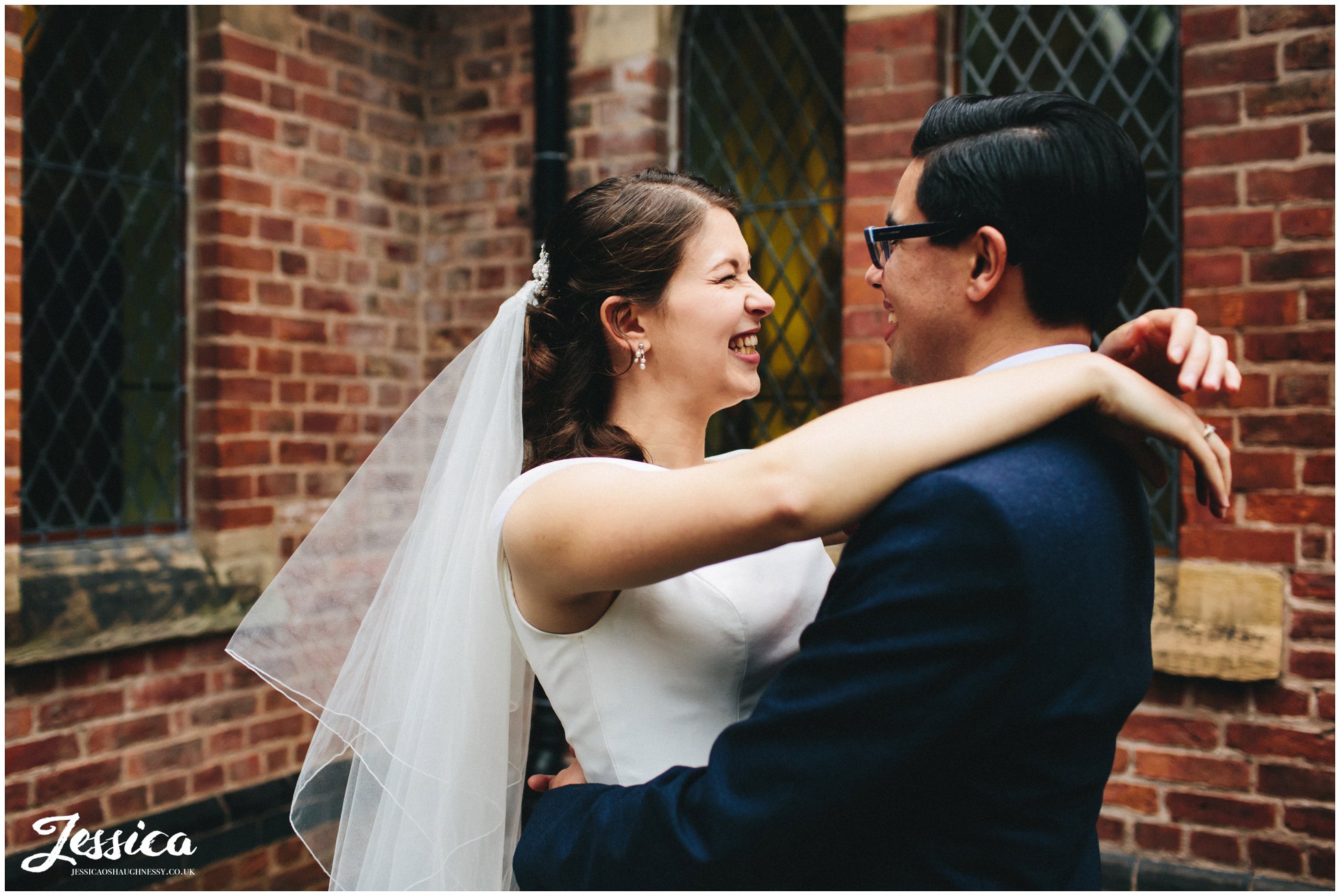 bride smiles with her arms around the grooms neck