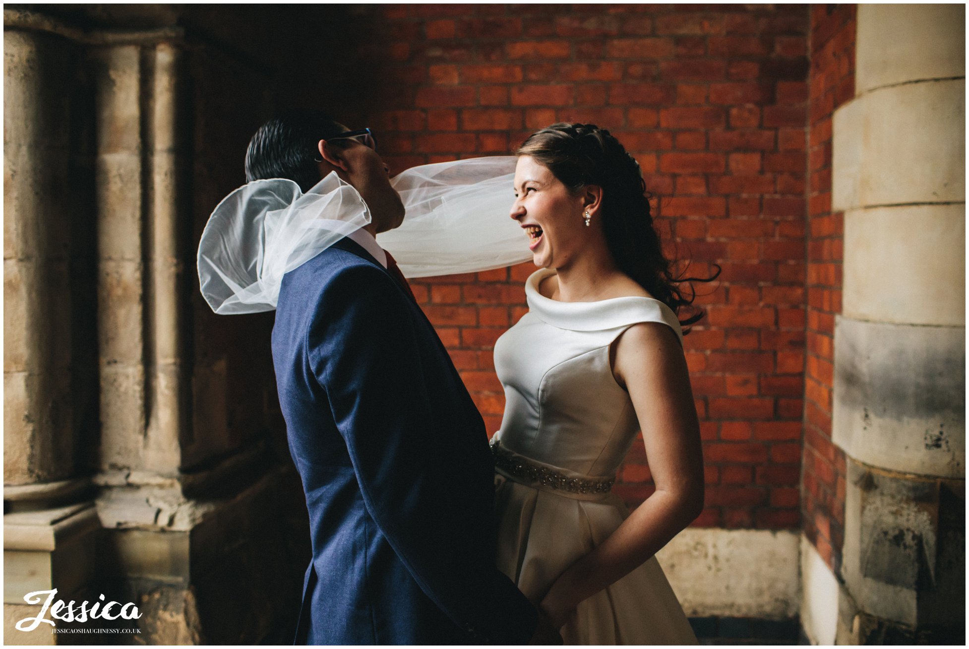 wind wraps brides veil around the grooms face