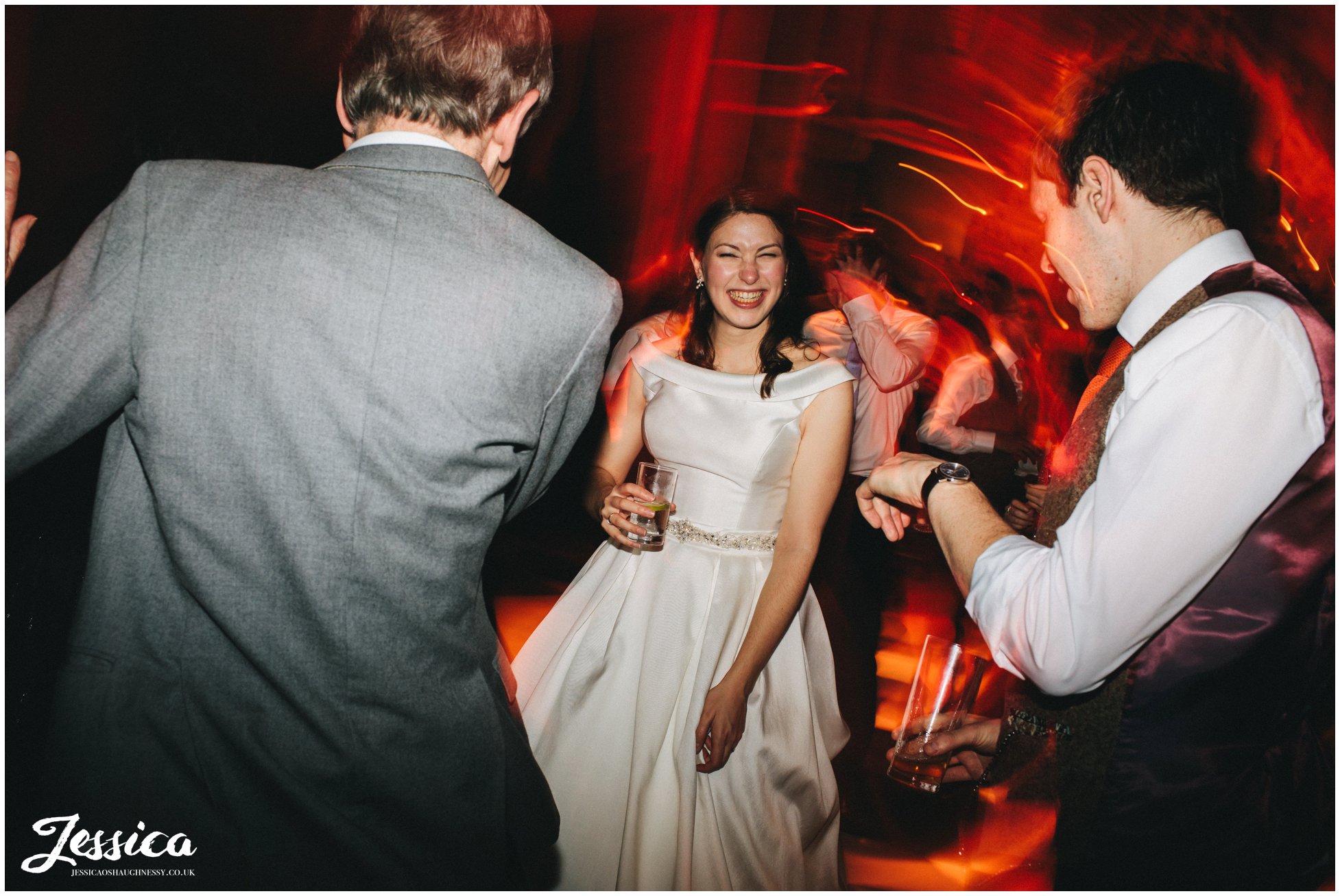 bride laughs on the dancefloor with her friends