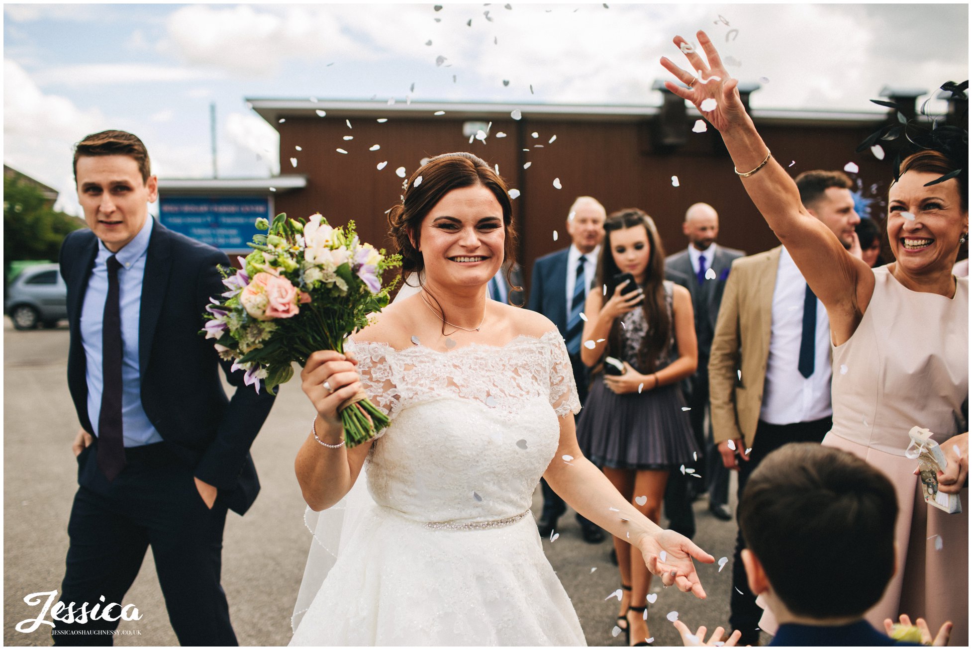 guests throw confetti over the bride