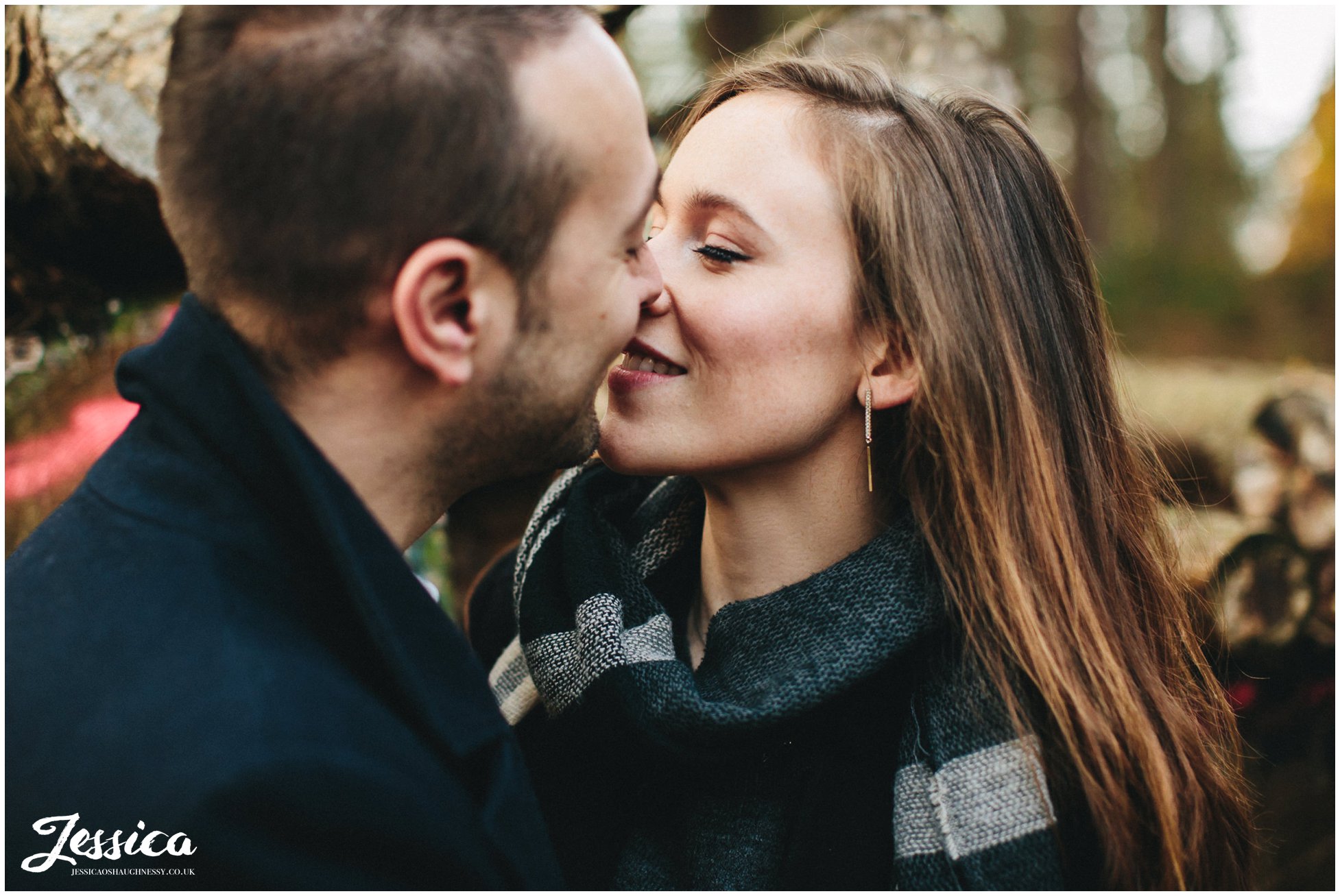 engaged couple kissing in delamere forest in cheshire