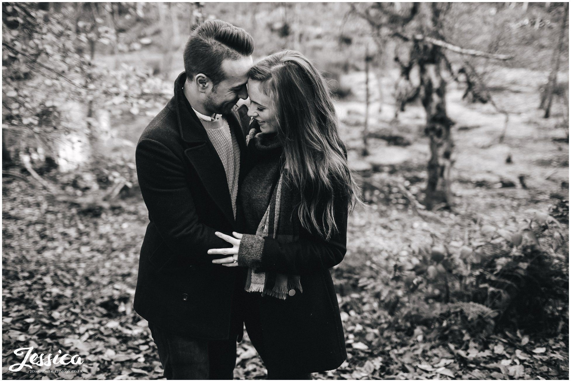 black and white shot of engaged couple embracing - delamere forest in cheshire